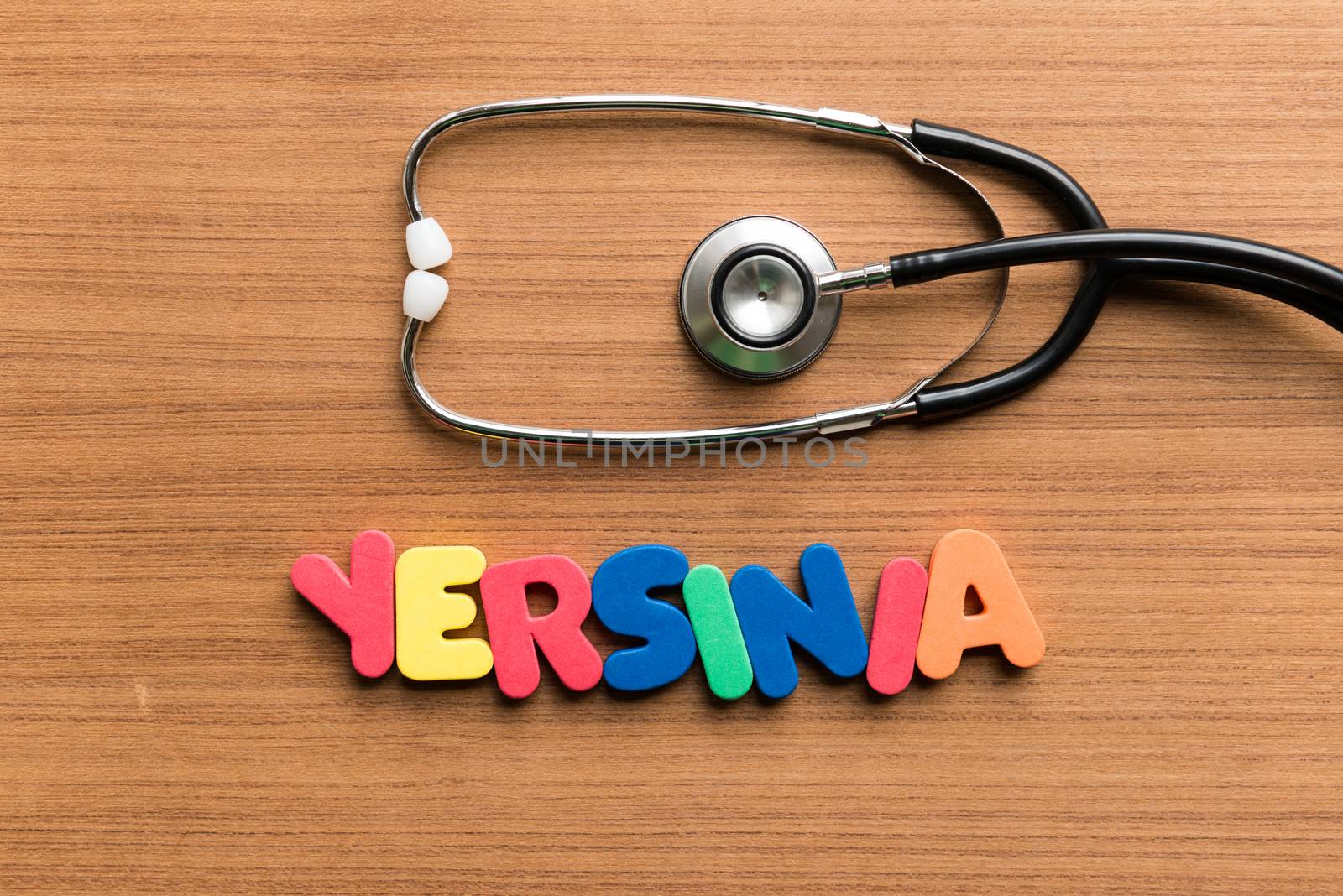 yersinia colorful word with stethoscope on wooden background