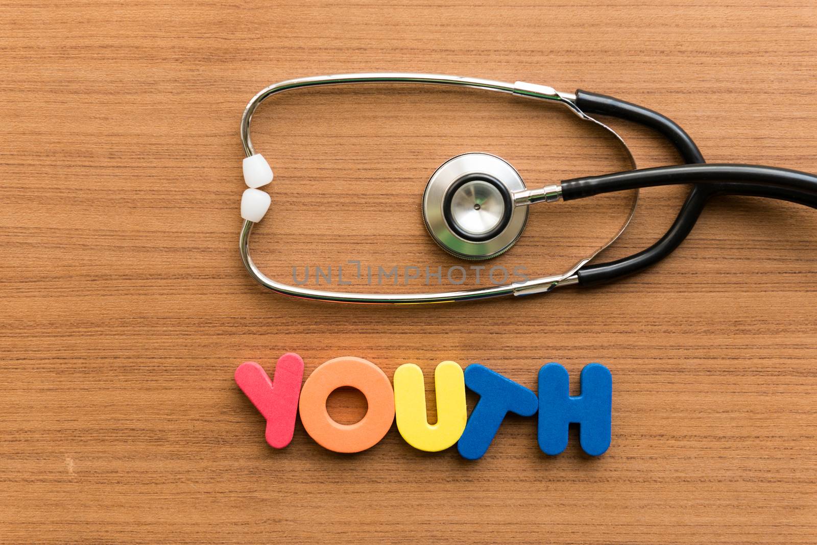 youth colorful word with stethoscope on wooden background