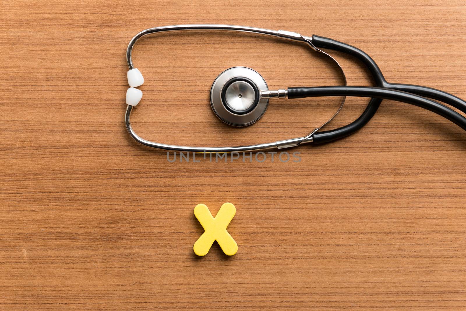 x colorful word with stethoscope on wooden background