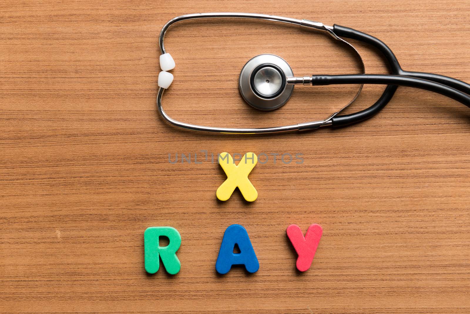 x ray colorful word with stethoscope on wooden background