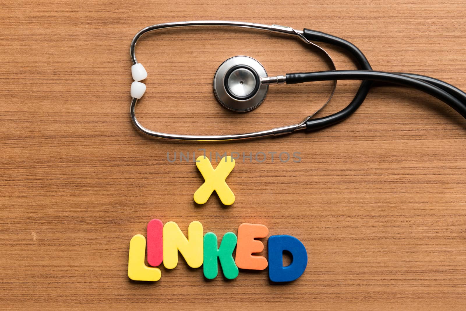 x linked colorful word with stethoscope on wooden background