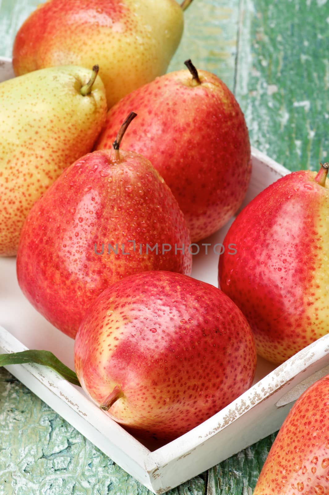 Ripe Yellow and Red Pears in White Wooden Tray Cross Section on Cracked Wooden background