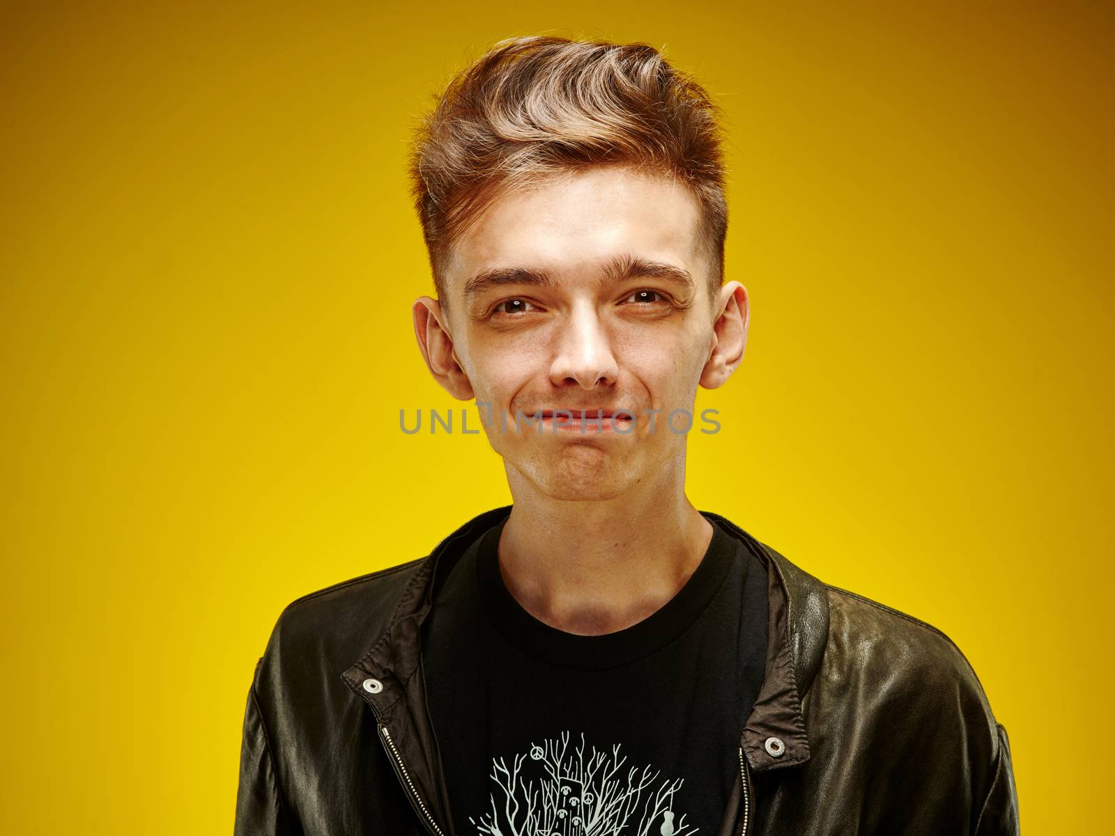 Emotional portrait of a teenager on a yellow background