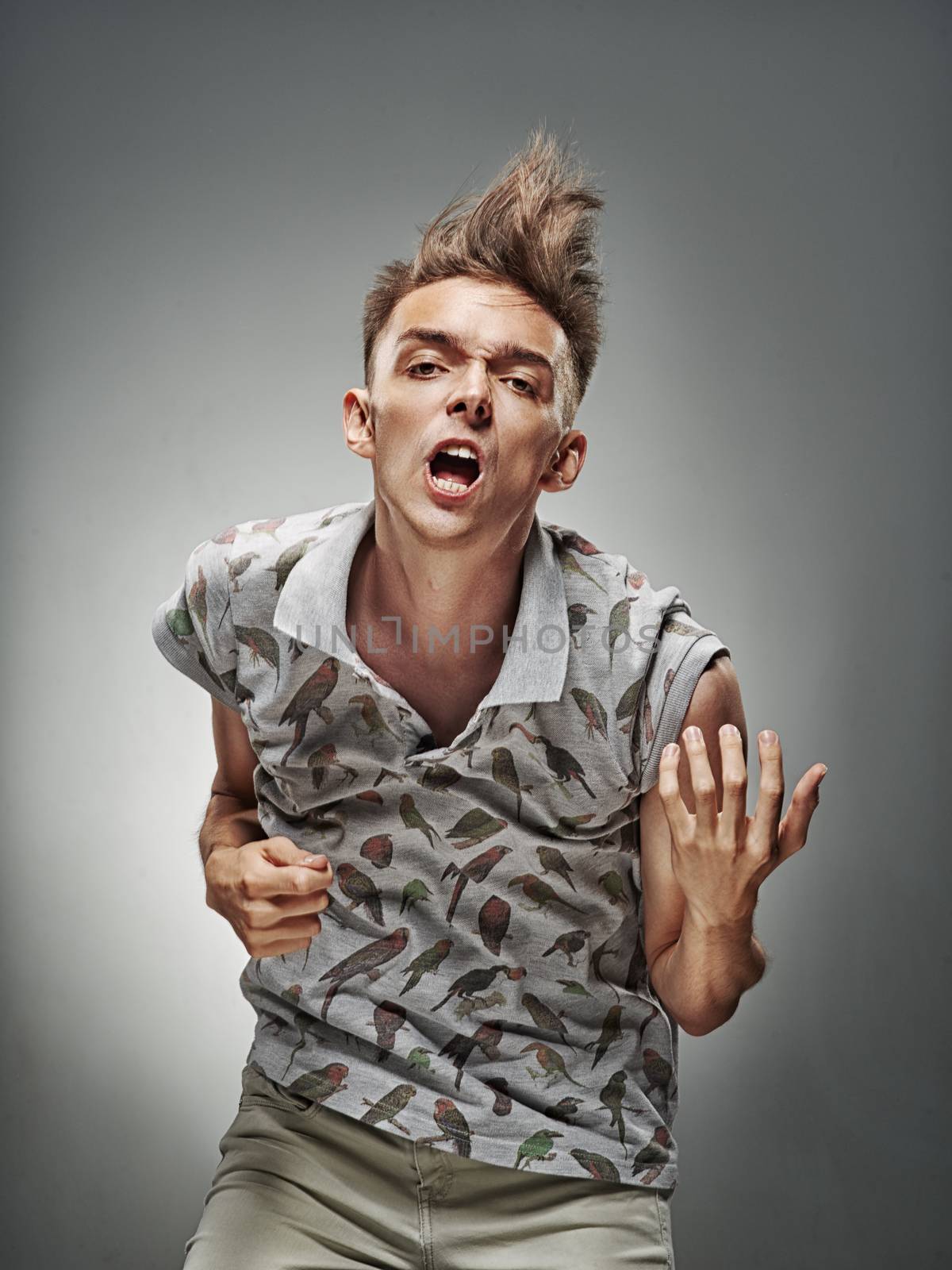 Emotional portrait of a teenager dancing on a gray background