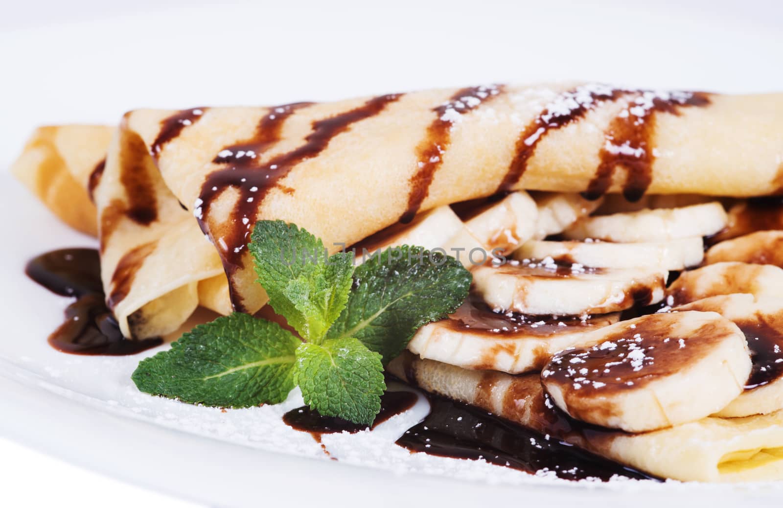 Pancakes stuffed bananas and chocolate on a plate by kzen