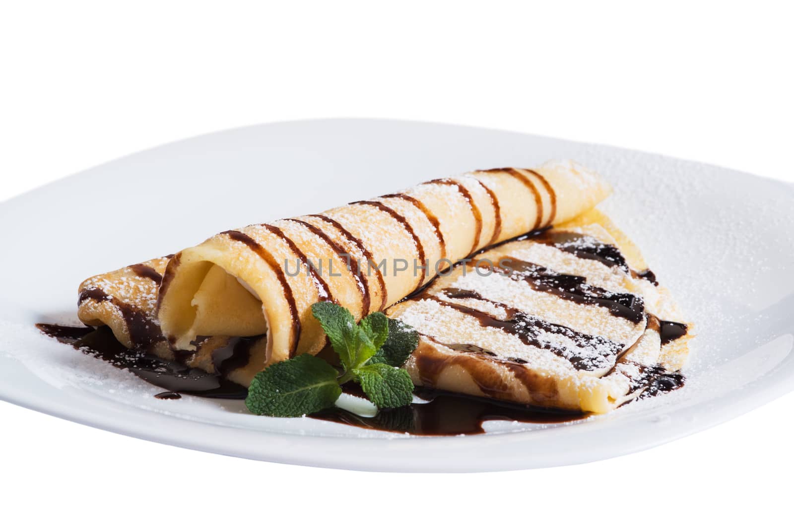 Pancakes with chocolate sauce and mint  on a plate, isolated