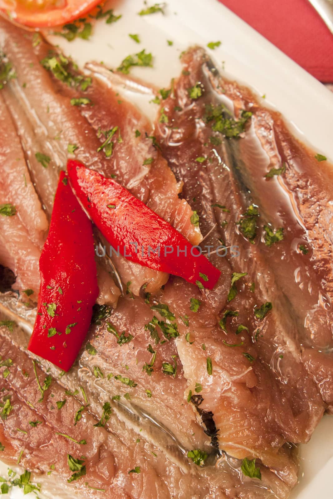 marinaded sprat with vegetables on white plate
