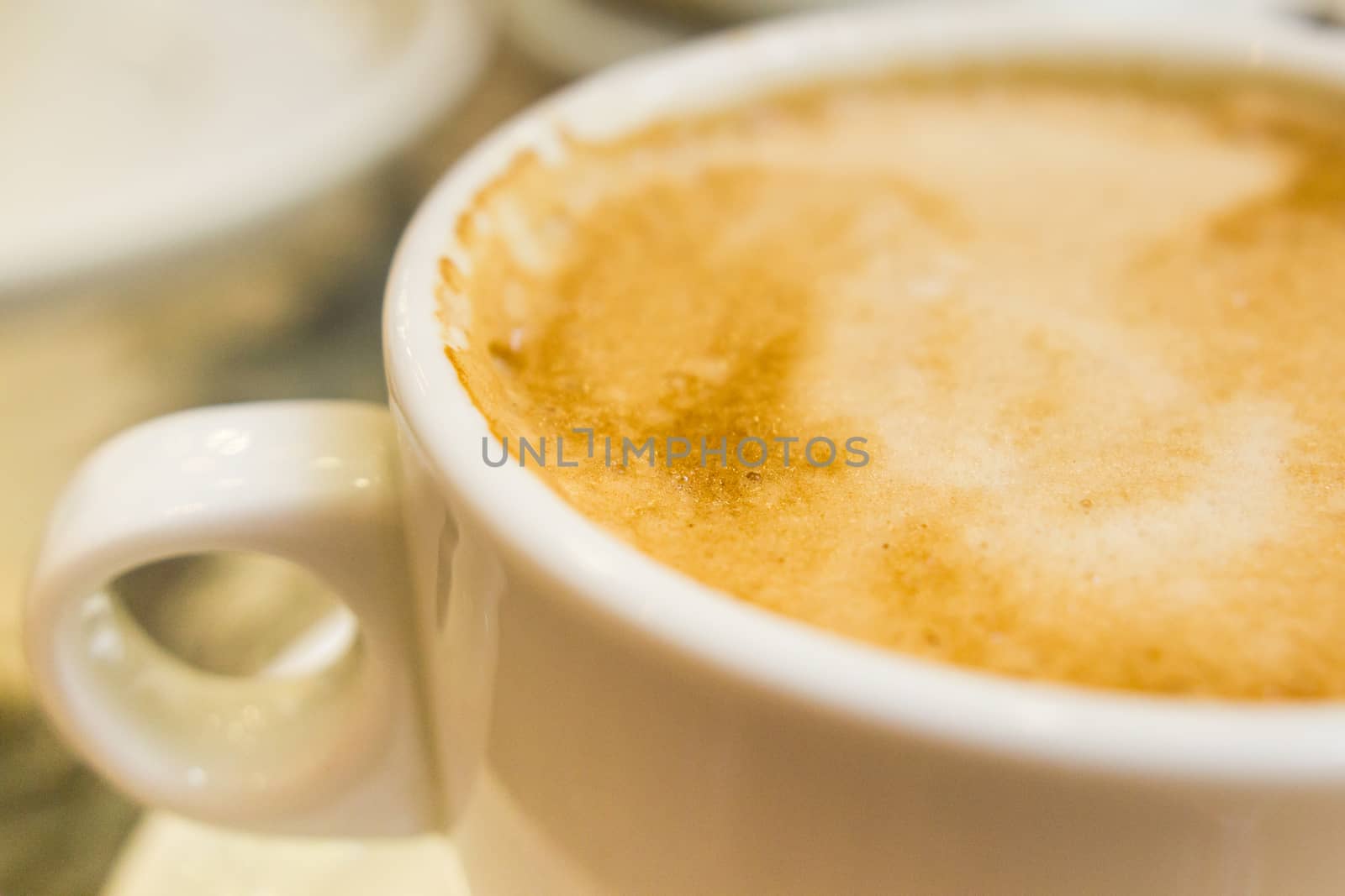 white ceramic cup with hot coffee  close up blurred