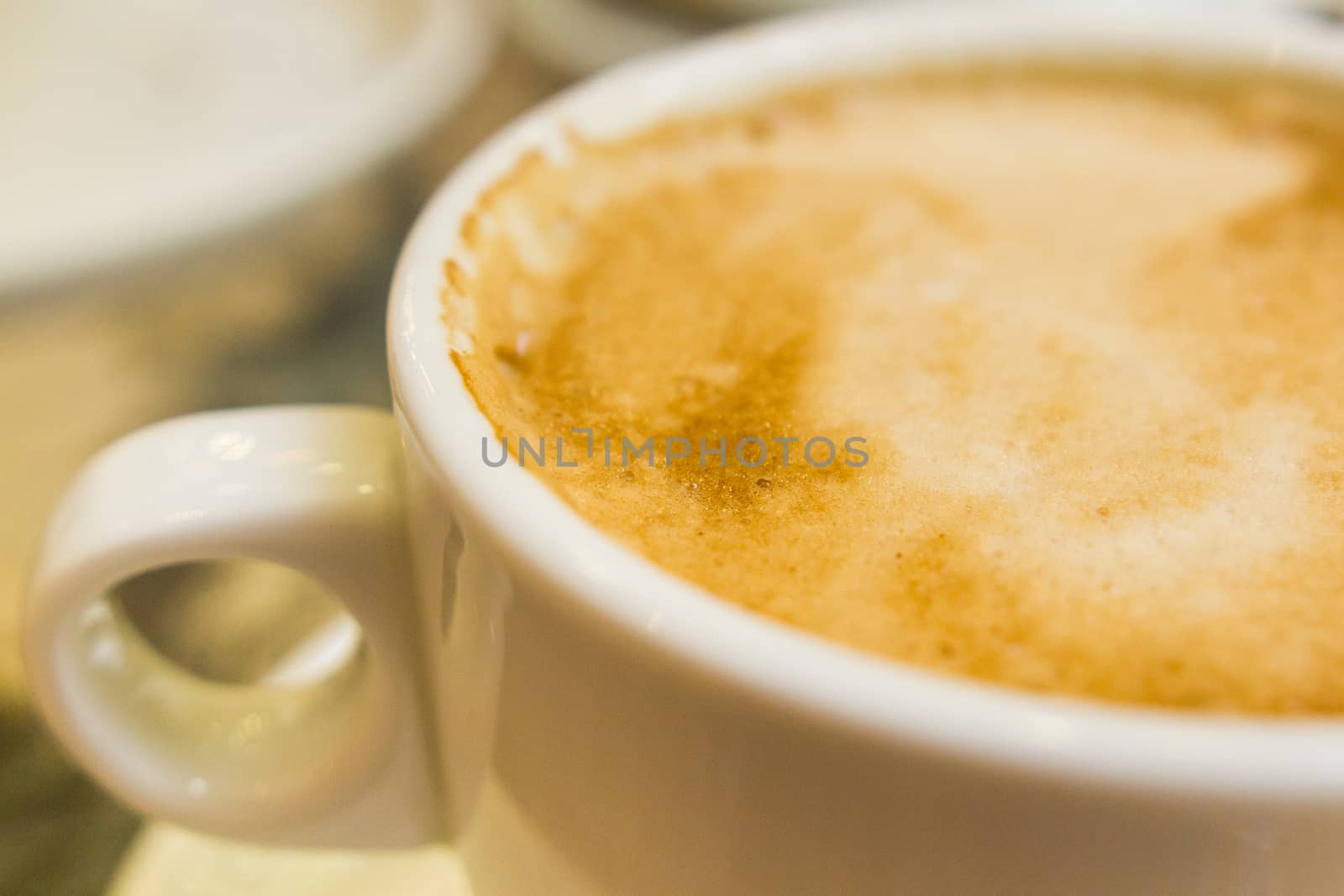 white ceramic cup with hot coffee  close up blurred