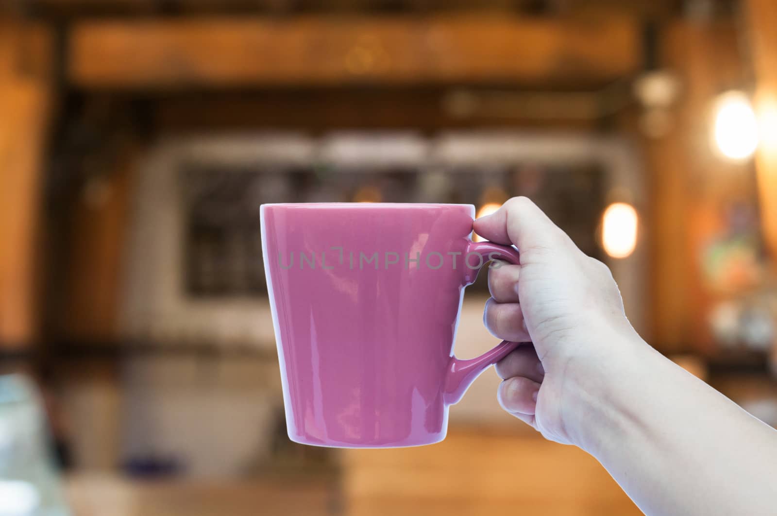 Woman hand holding coffee cup in coffee shop by punsayaporn