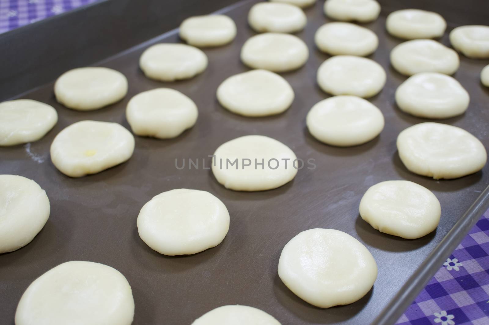 Chinese Pastry Mung Bean on brown oven tray have purple tablecloth as background.