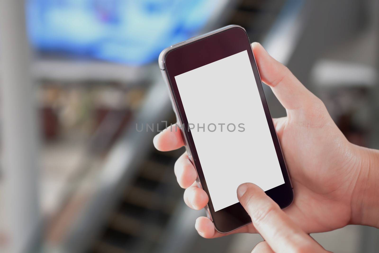 Hand holding smart phone with white screen on blurred background, stock photo