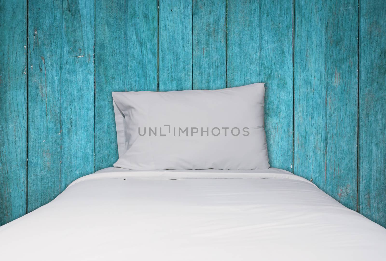 Close up white bedding and pillow on blue wooden texture backgro by punsayaporn