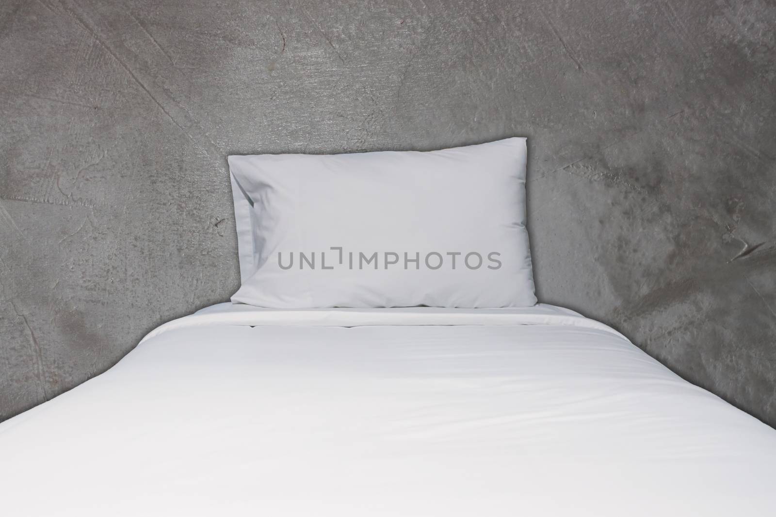 Close up white bedding and pillow on concrete background by punsayaporn