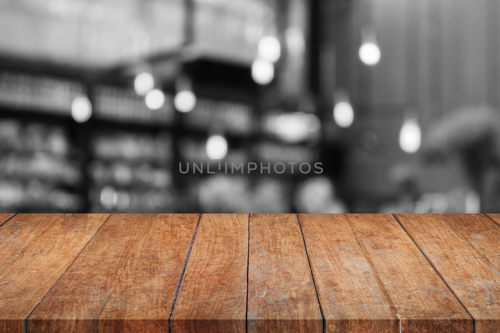 Wooden tabletop with black and white coffee shop blurred background, stock photo