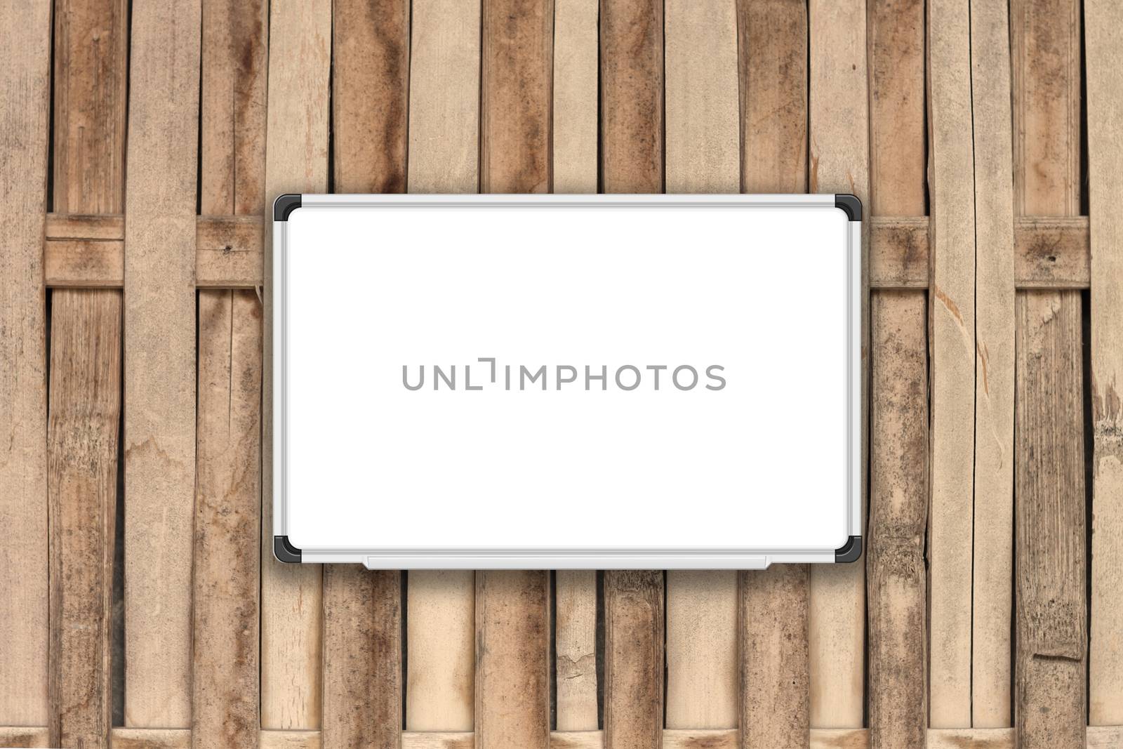 Blank white board on bamboo fence with sepia filter, stock photo