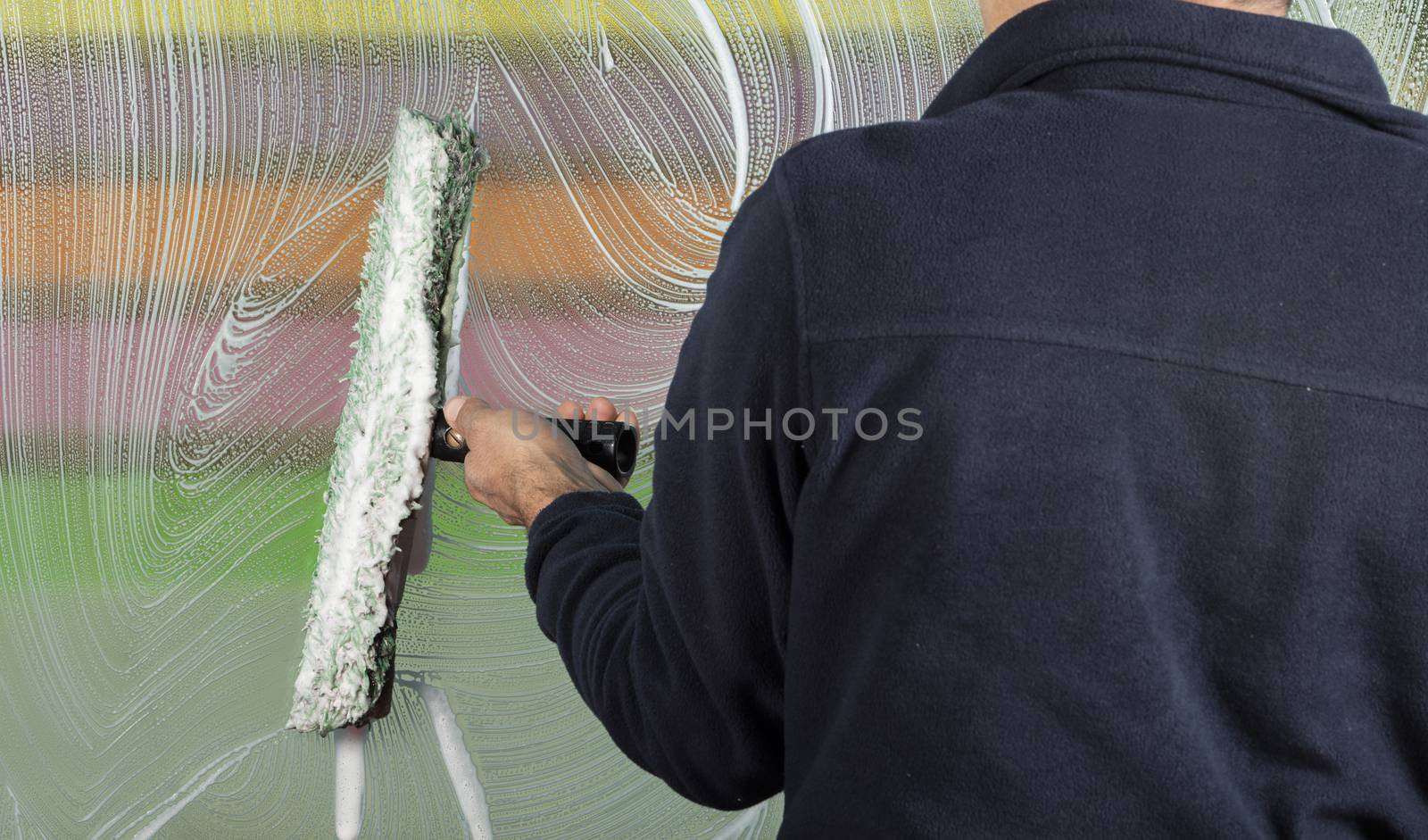 window cleaner using a squeegee to wash a window by senkaya