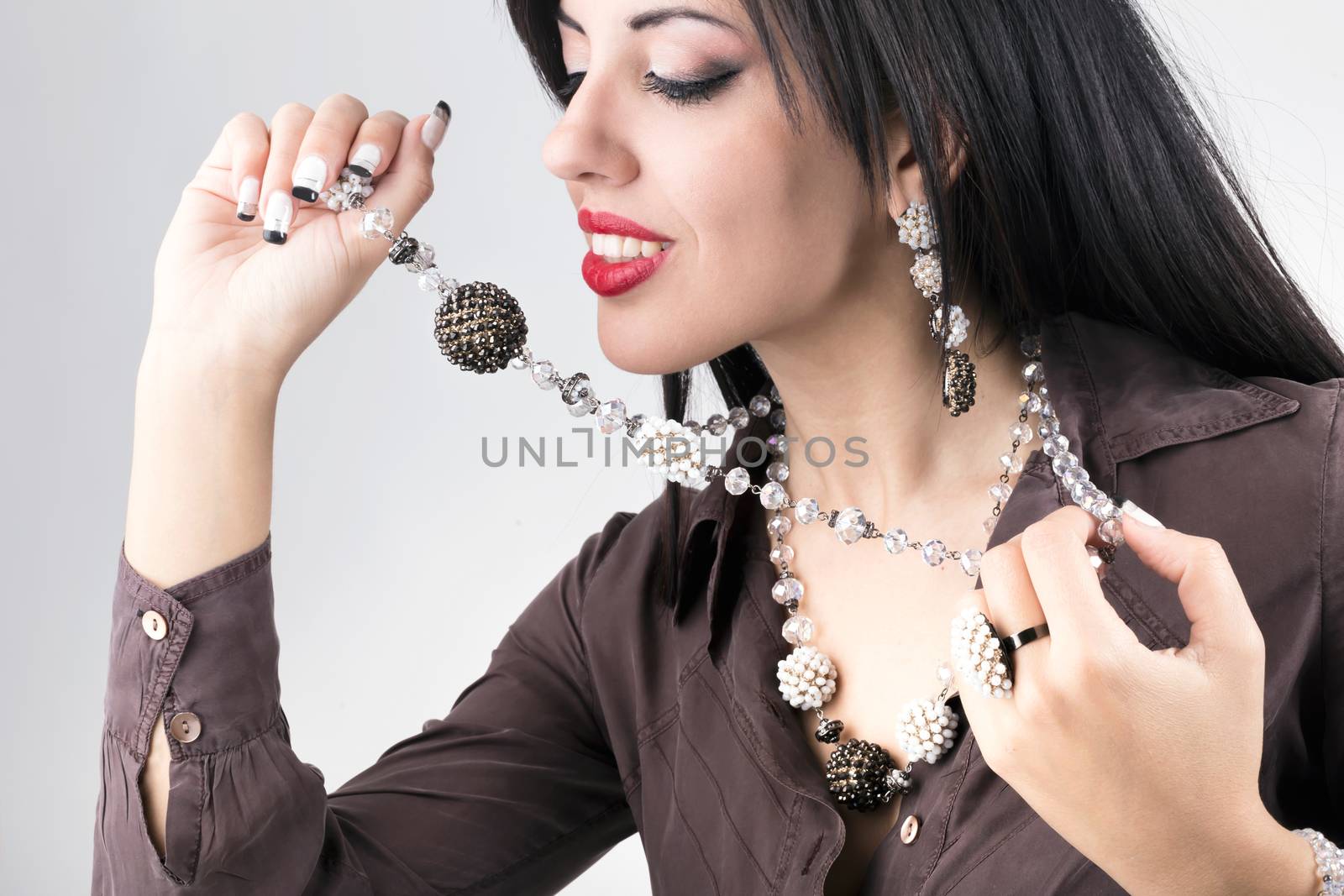 Beautiful girl with brown and white jewelry. Beauty young woman make-up