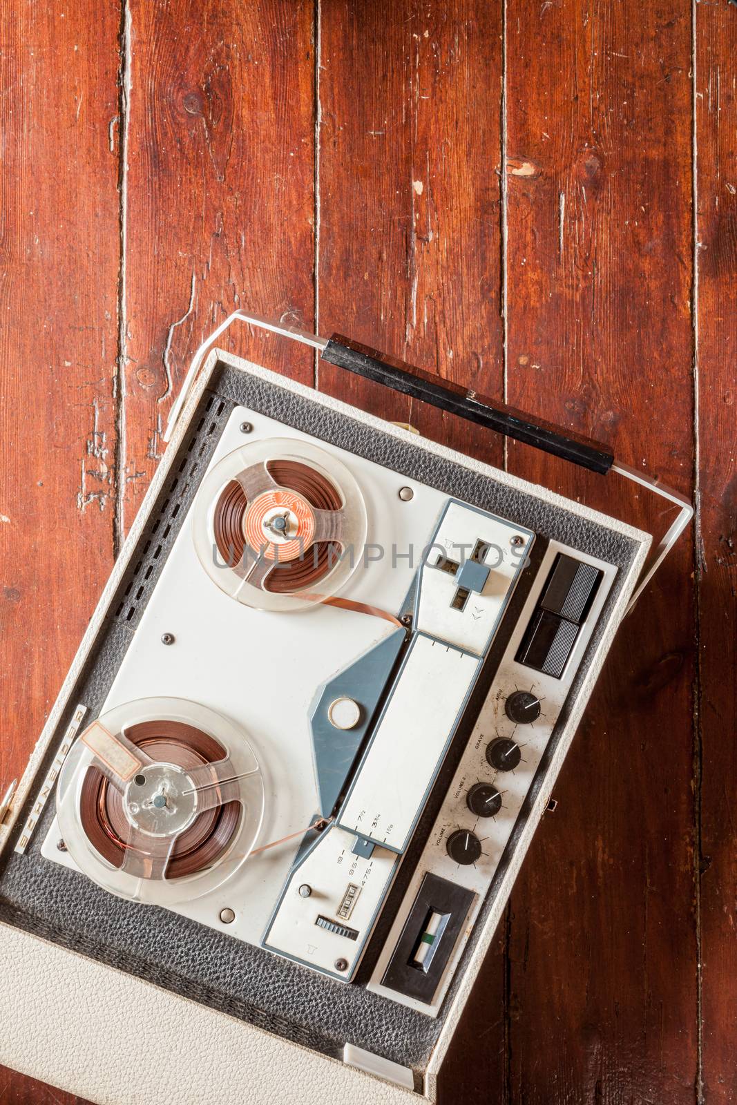 Old tape recorder on wooden background with natural lighting