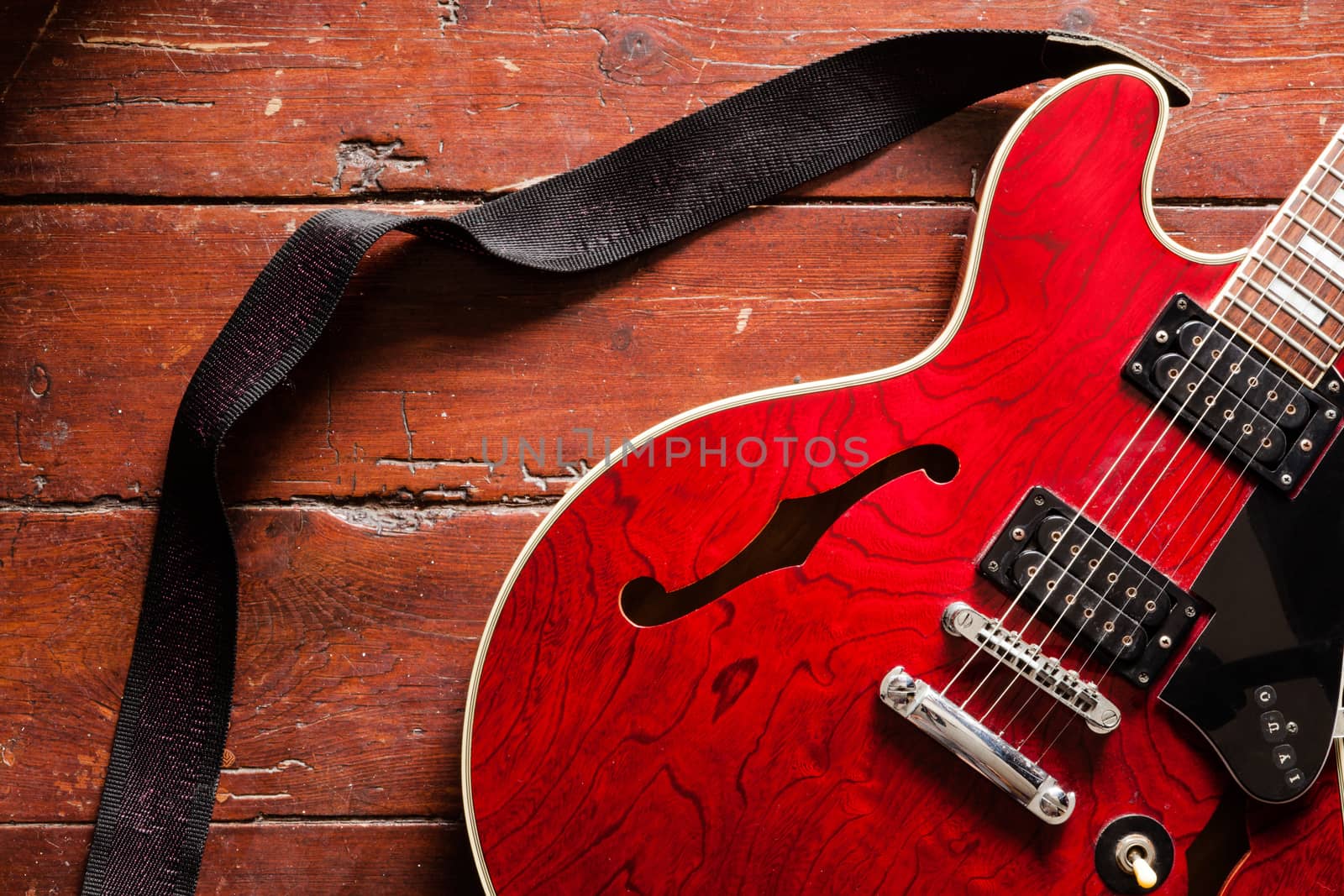 Electric guitar on wood background illuminated by natural daylight