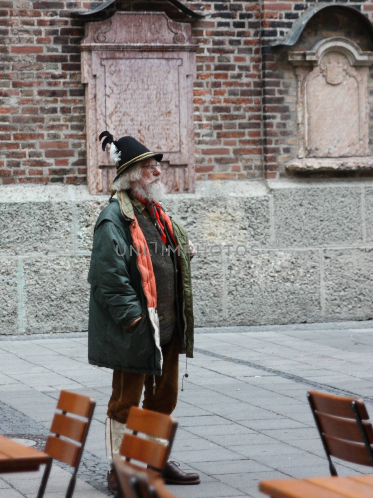 Munich, Germany - November 2011. Man in national dress Tyroleans stands on the street with a hat with a feather