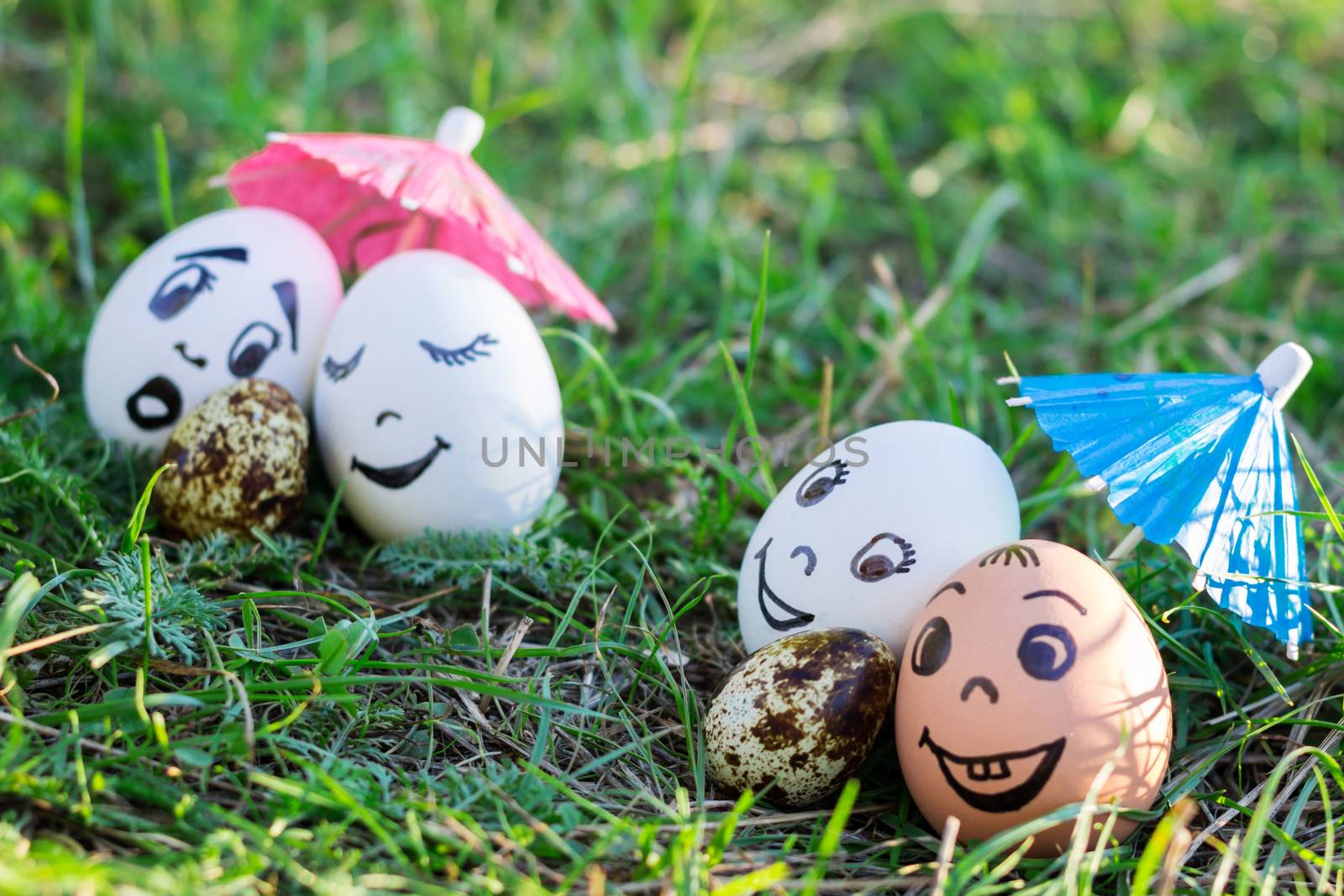 Funny eggs imitating two couples and surprised white parent of versicolored baby