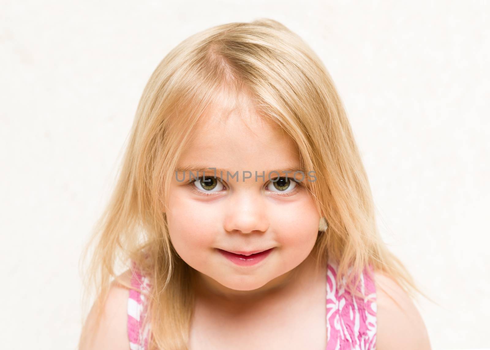 Portrait of beautiful blonde baby girl with cheeky grin by scheriton