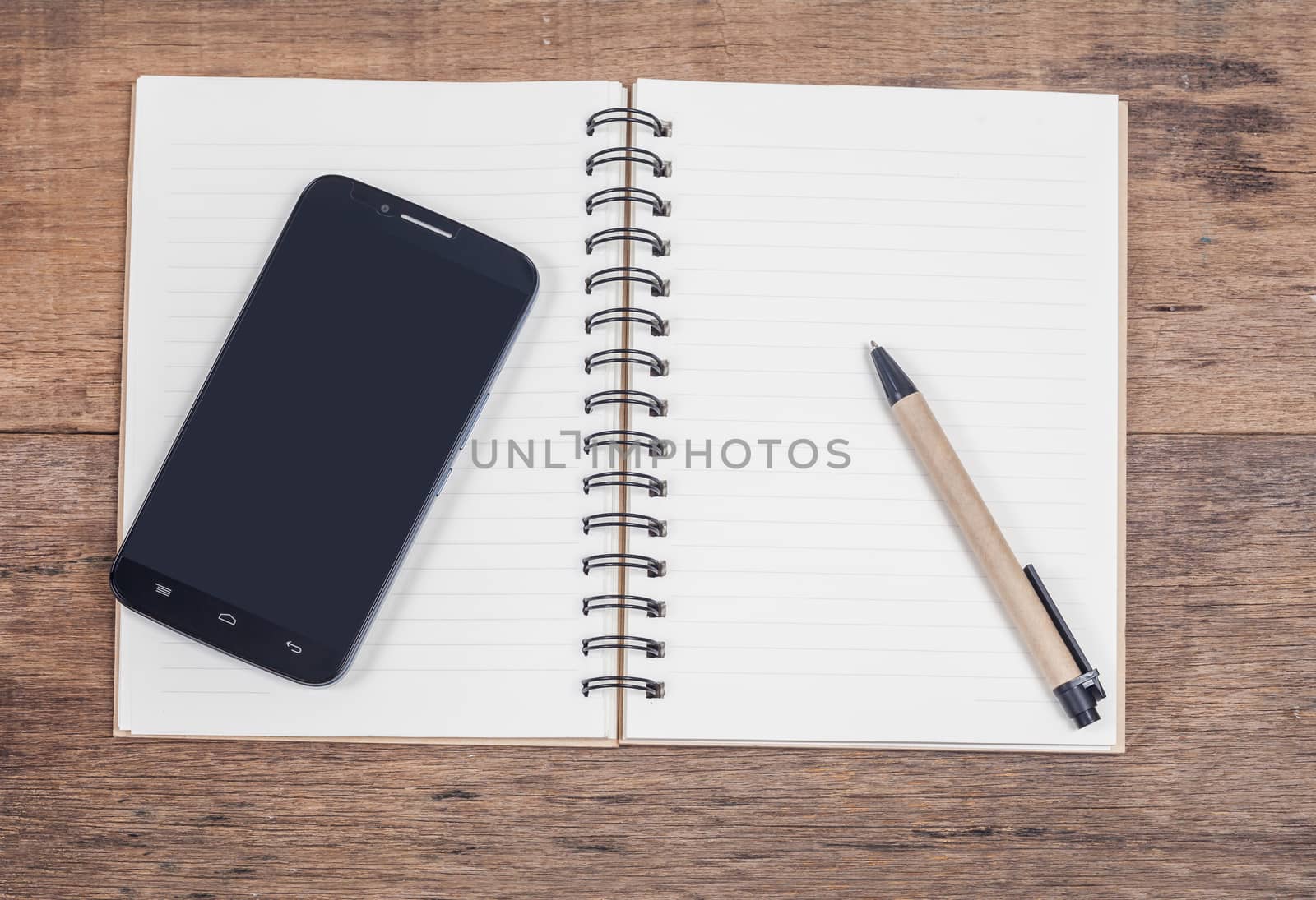 mobile phone and book note in vintage wooden desk