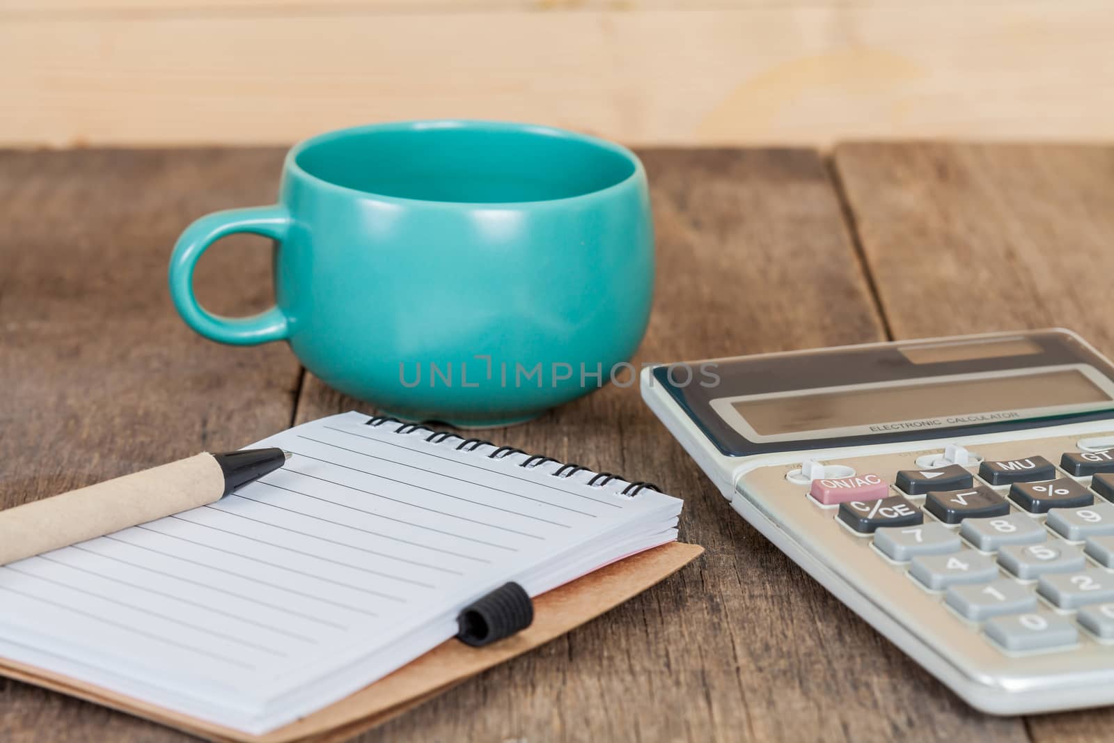 calculator, pen and cup of coffee on wood 