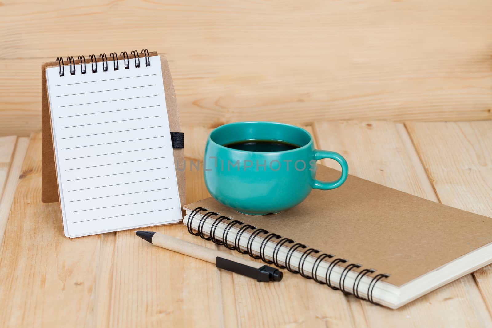 note book  and pen on wood table