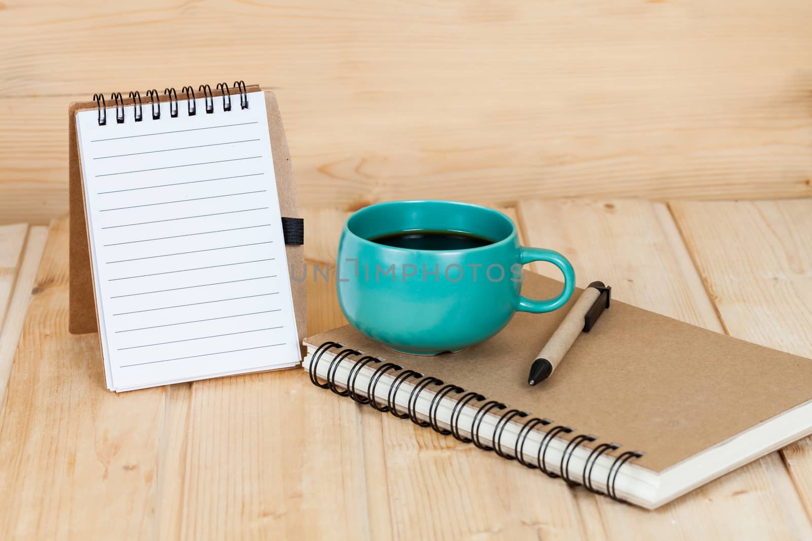 note book  and pen on wood table