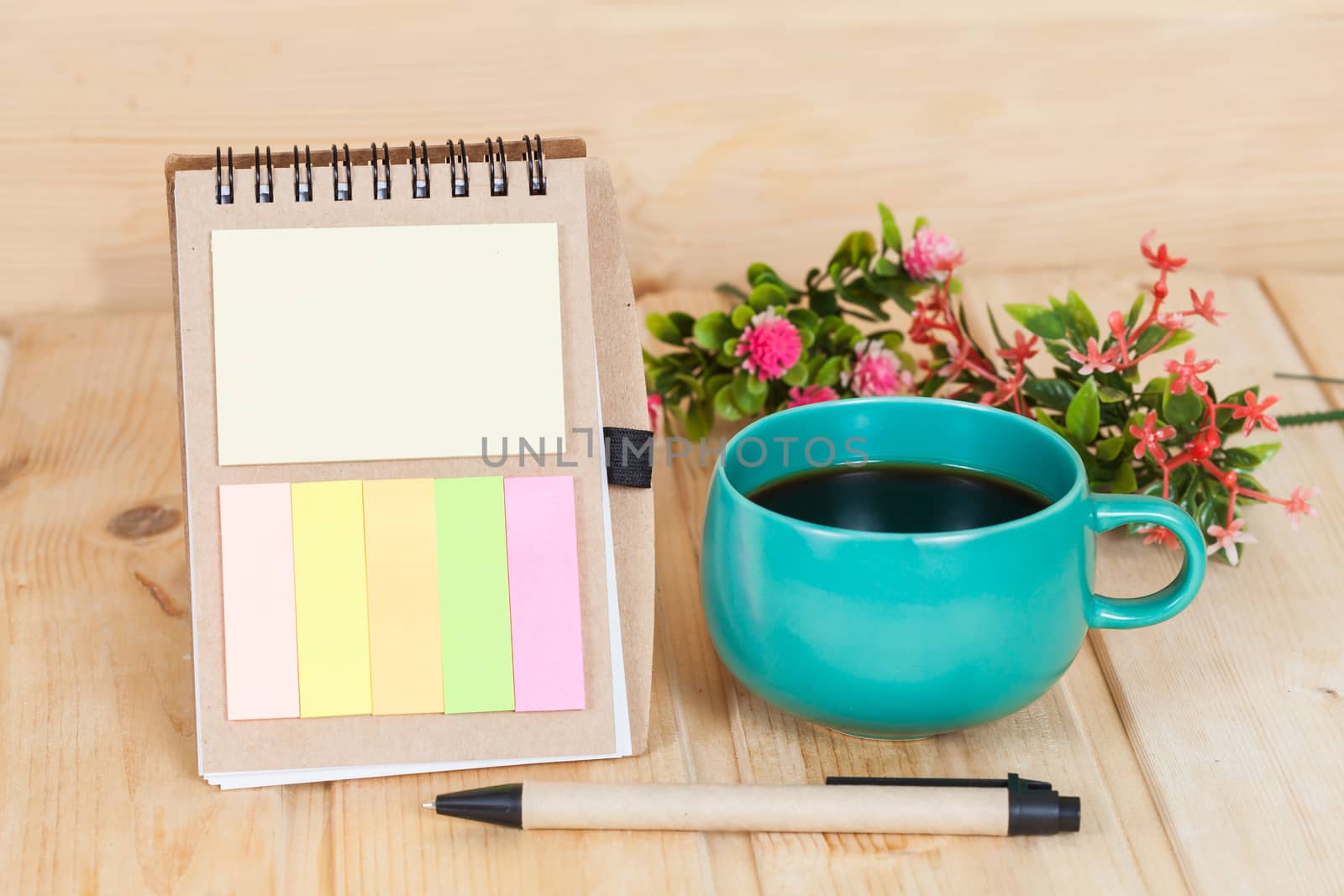 note book with cup and vase on wood table
