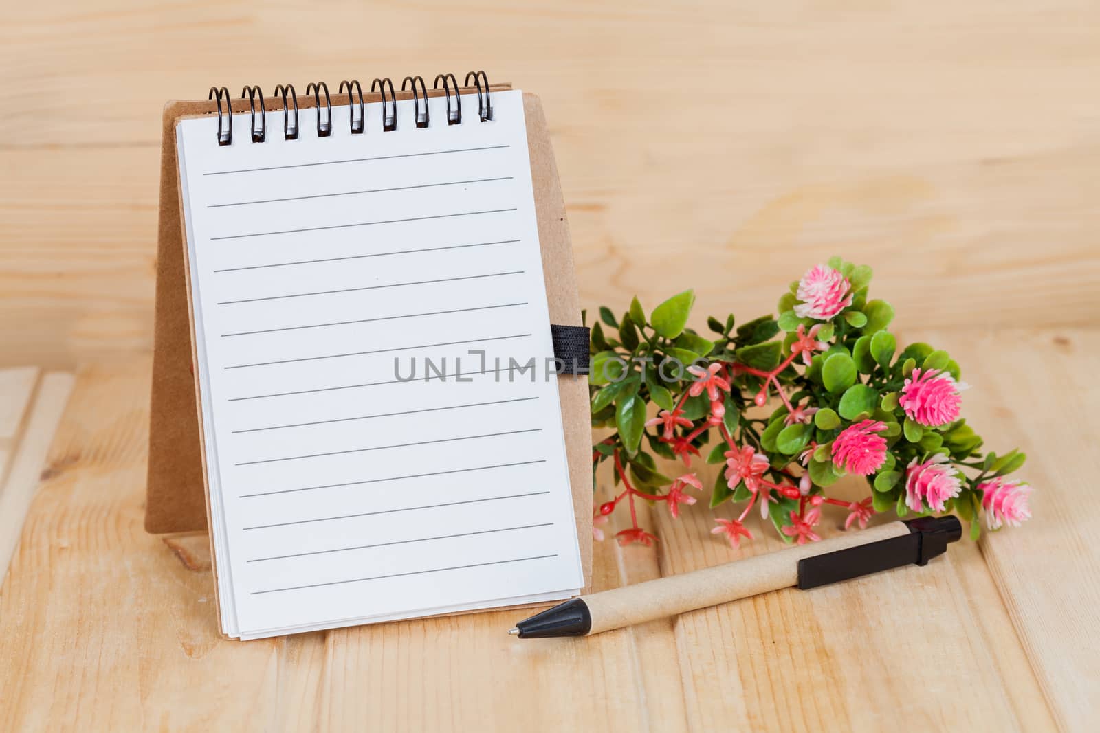 note book  and pen on wood table
