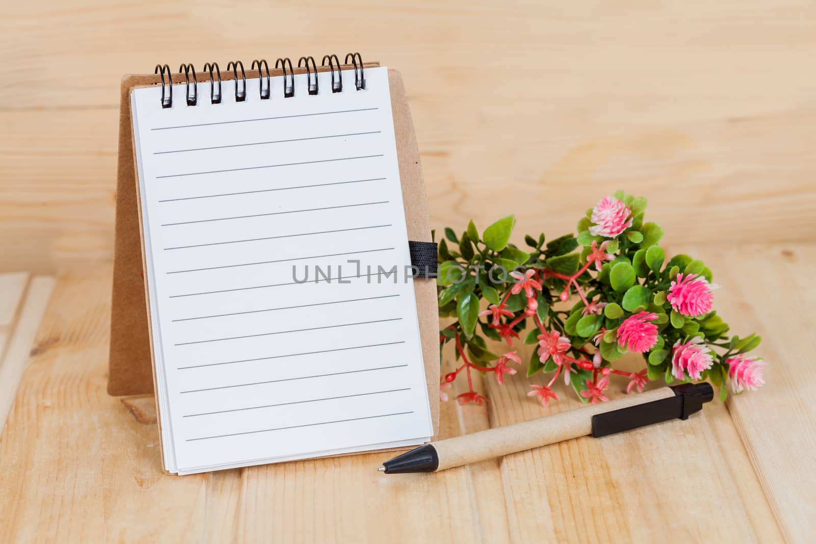 note book  and pen on wood table
