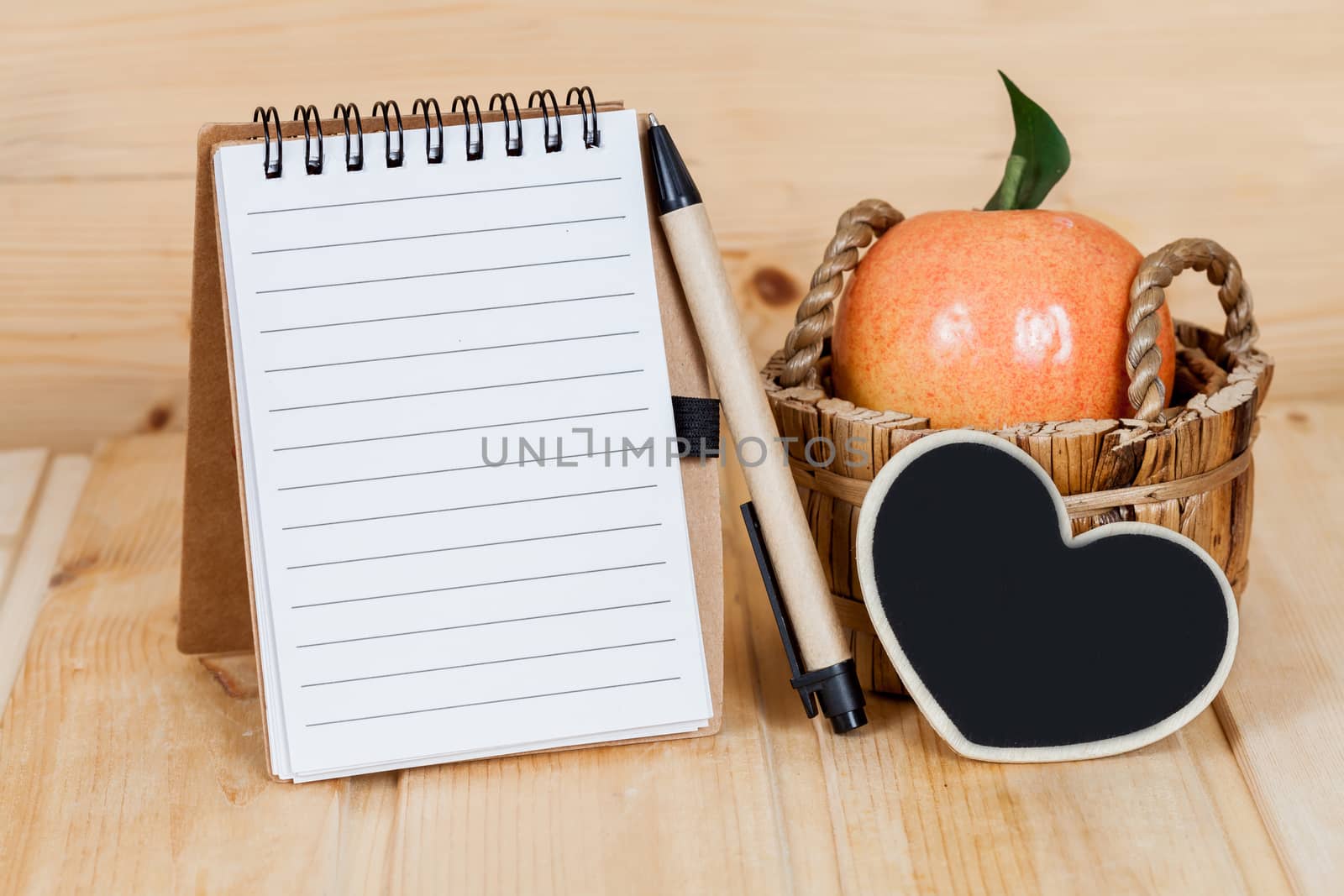 note book  and pen on wood table
