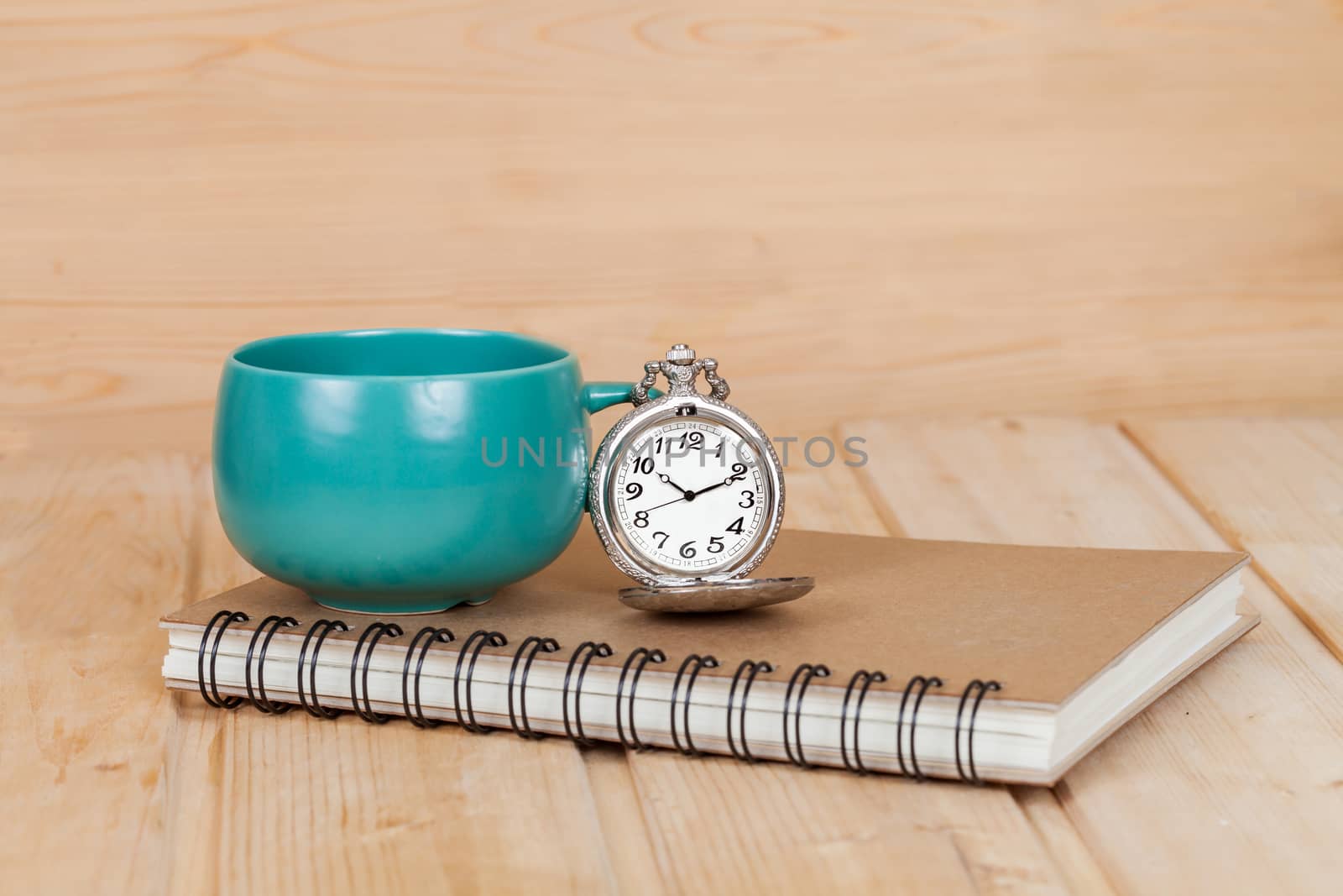 pocket watch and coffee cup on book