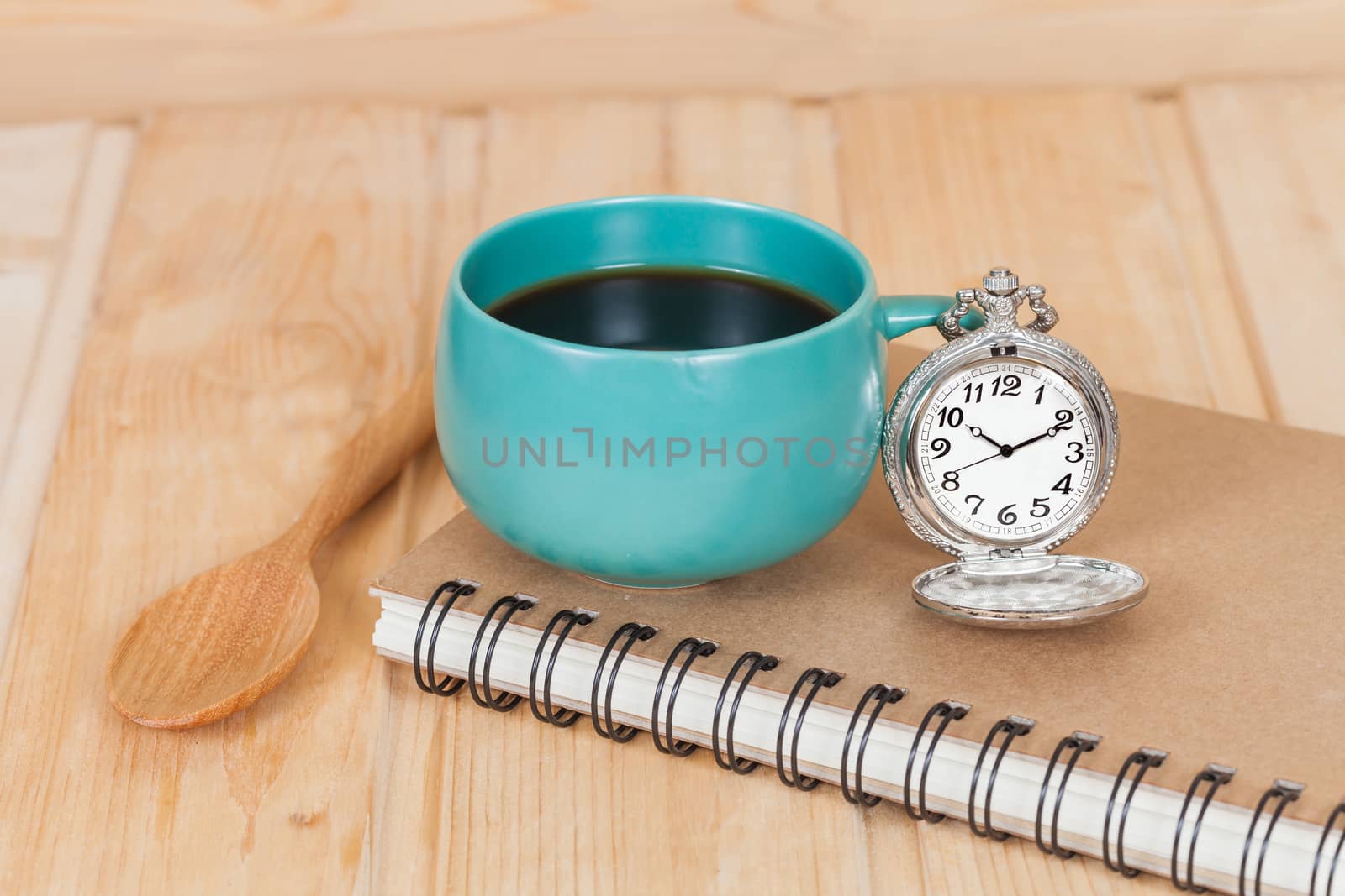 pocket watch and coffee cup on book