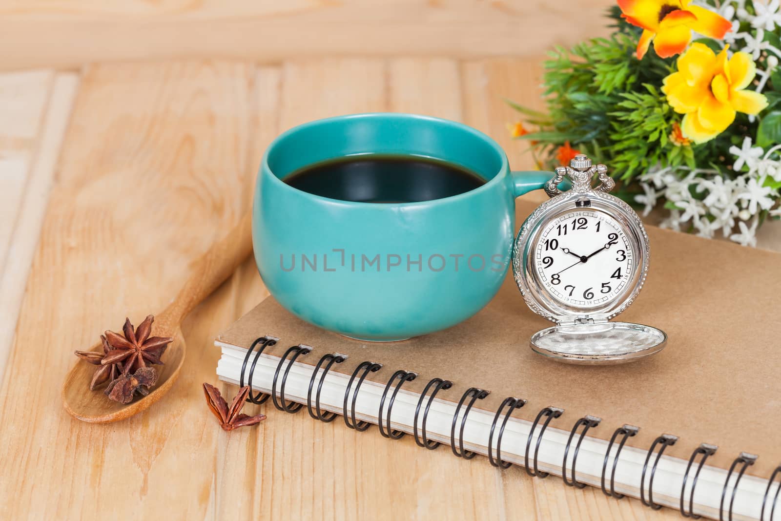 pocket watch and coffee cup on book