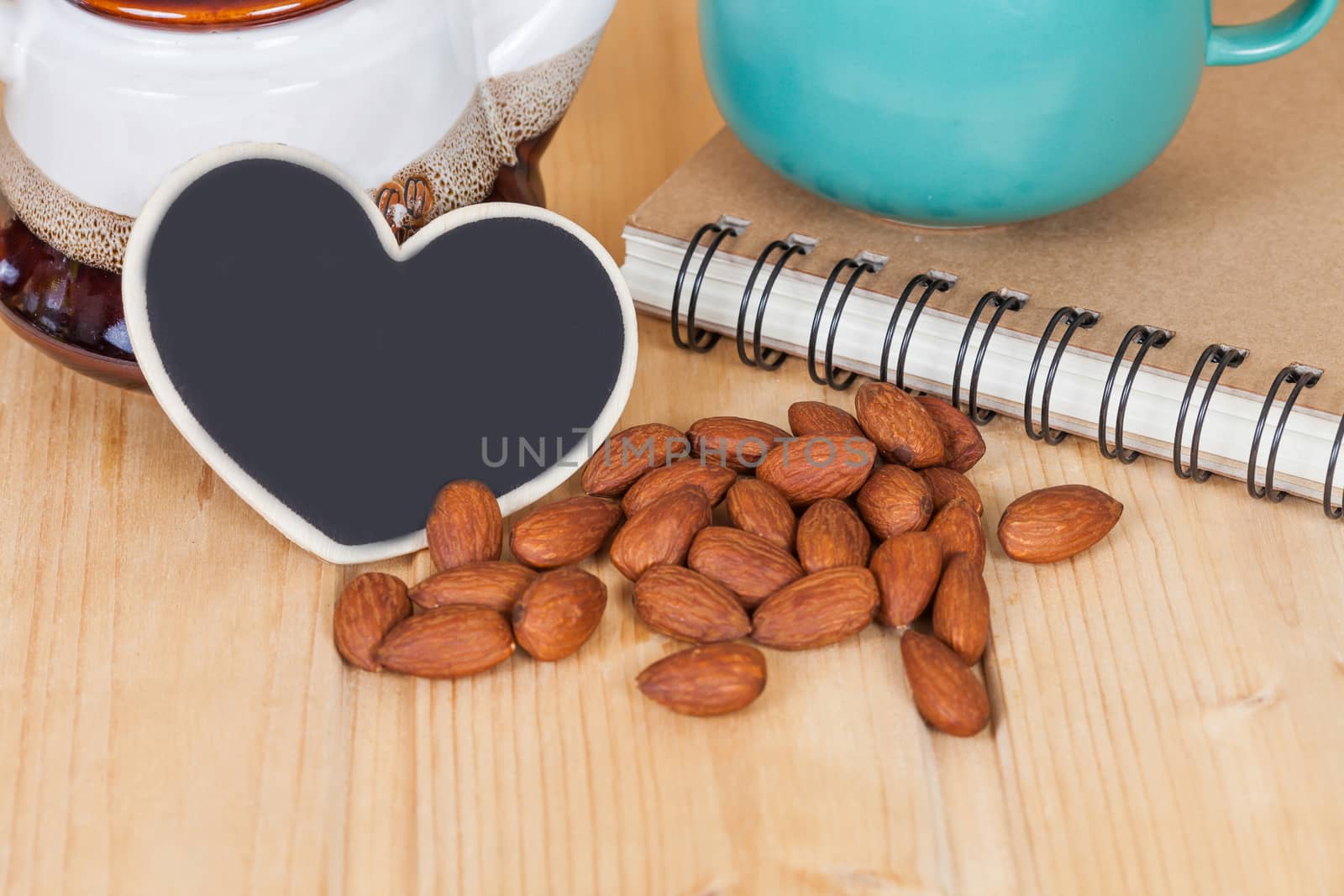 almond ,cup of coffee and book on  wood table