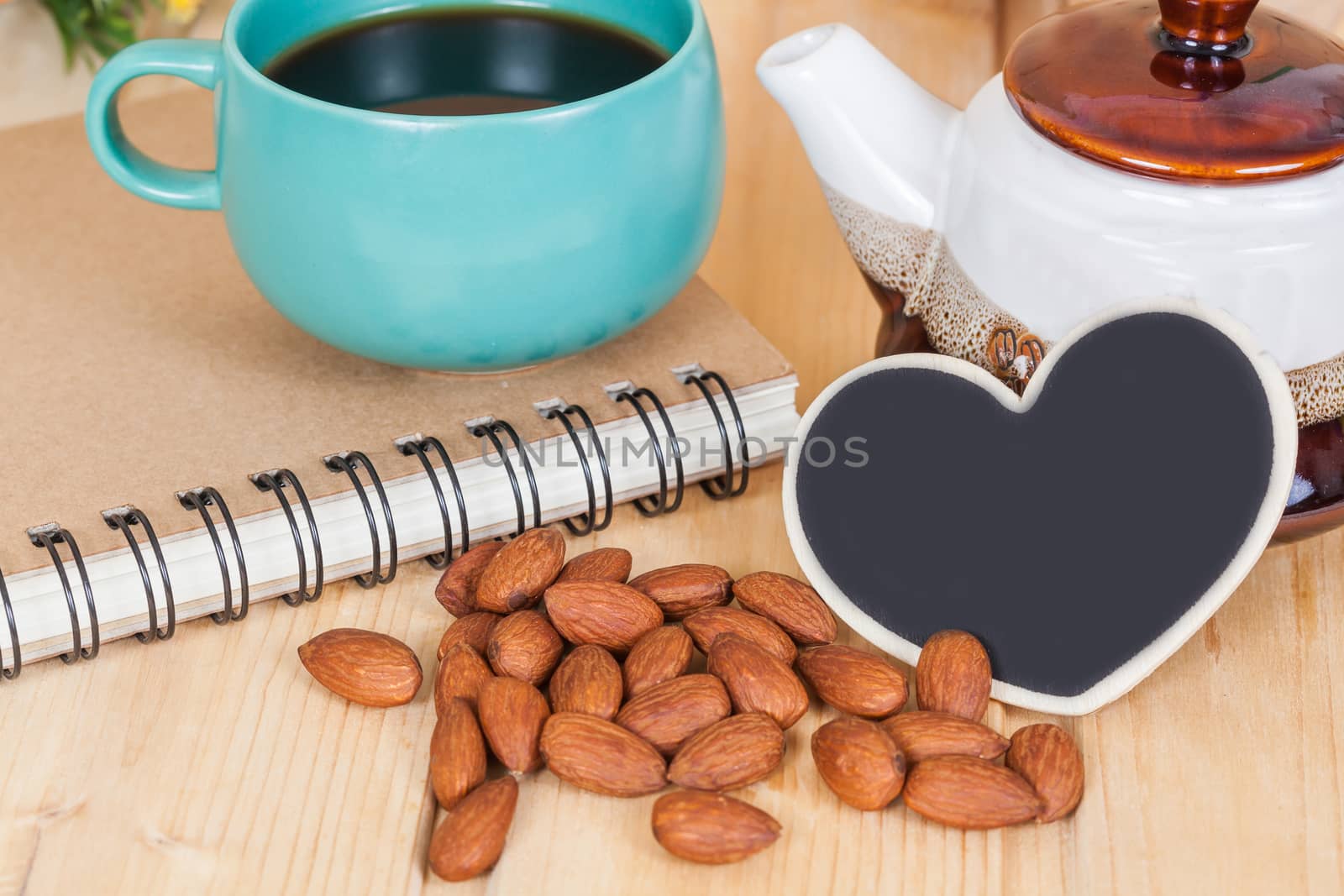 almond ,cup of coffee and book on  wood table