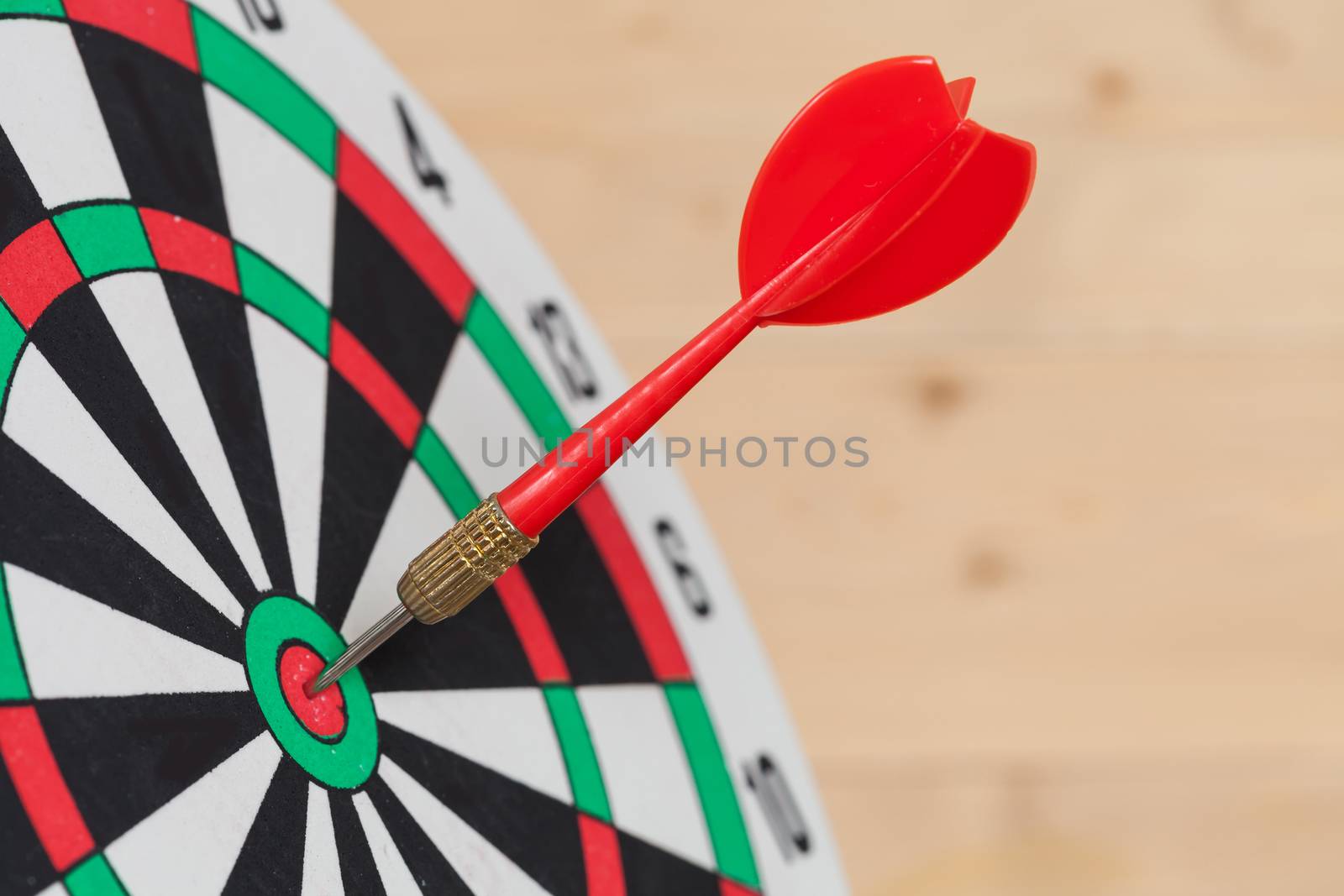 Dart arrow hitting in bullseye on dartboard