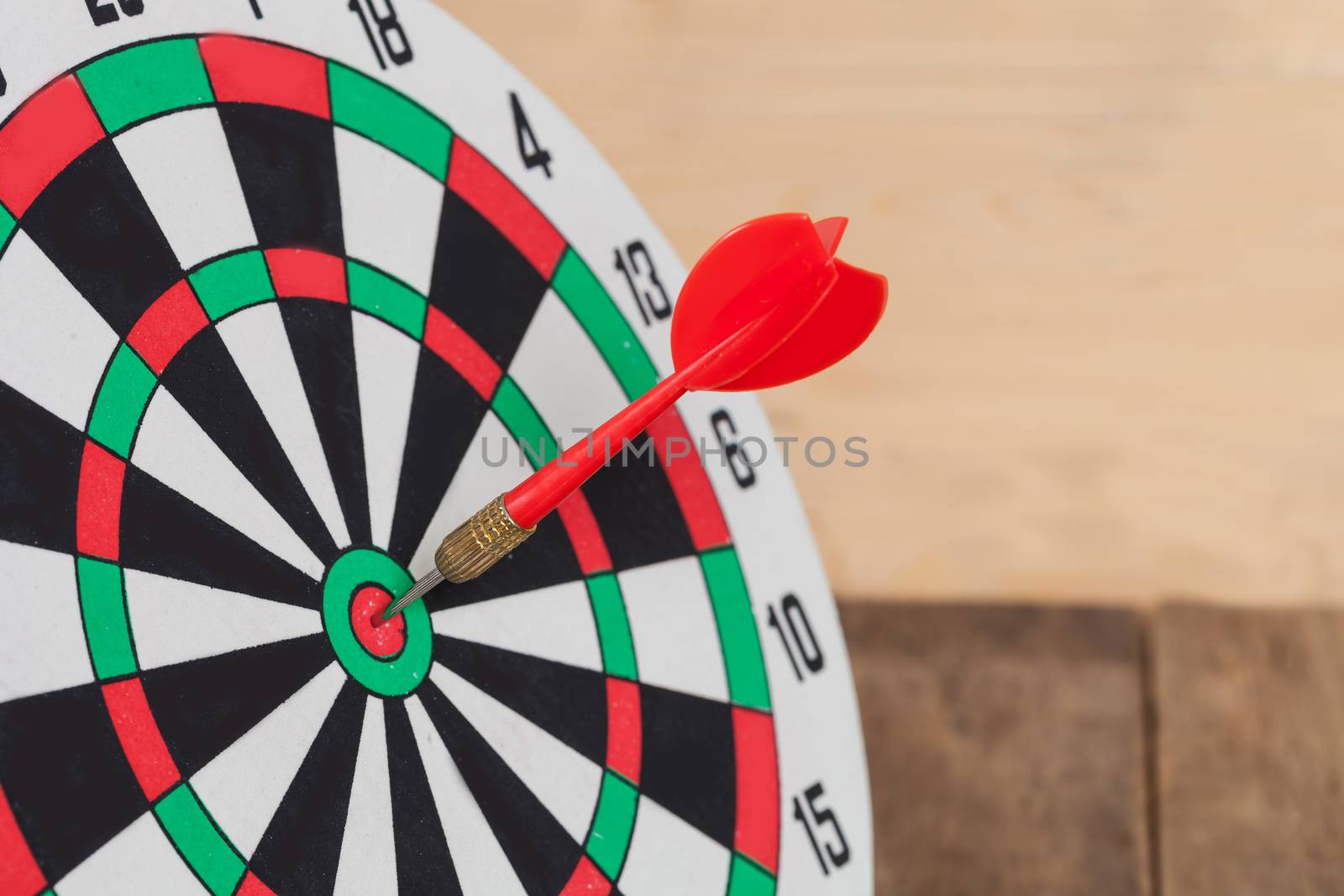 Dart arrow hitting in bullseye on dartboard