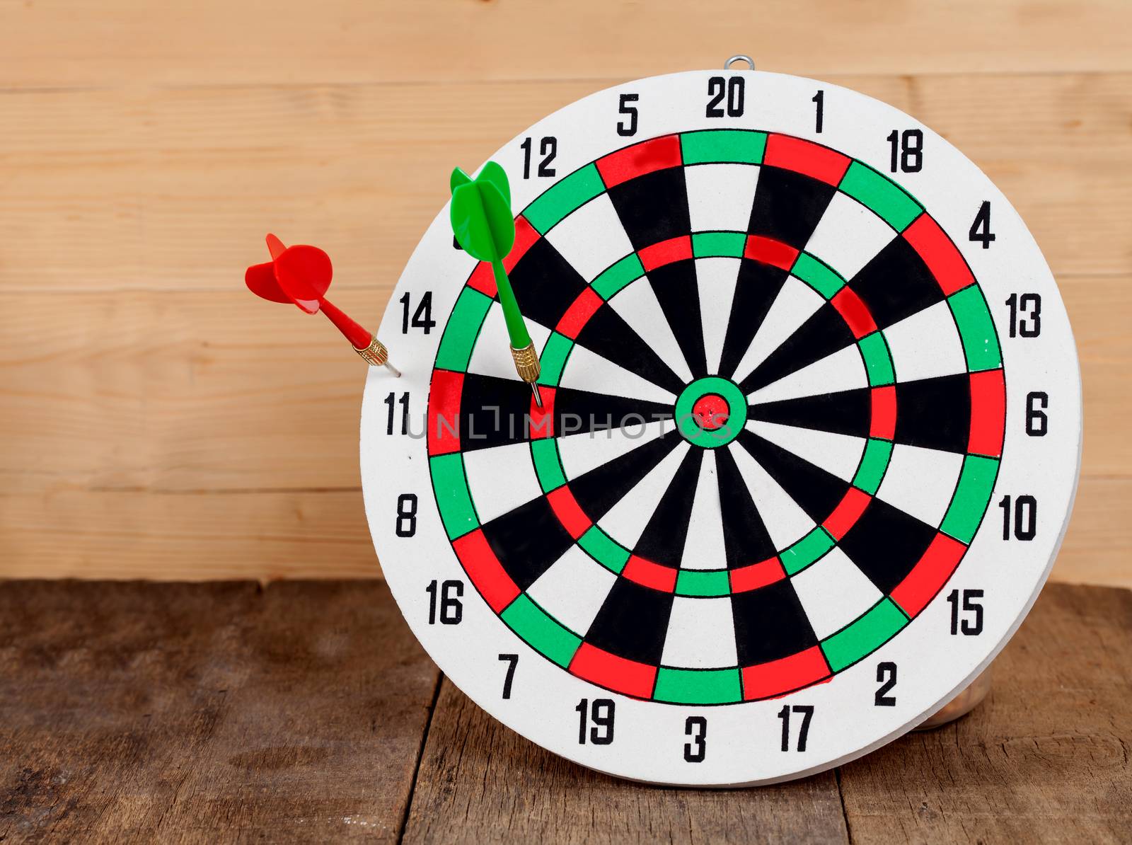 Dart arrow hitting in bullseye on dartboard