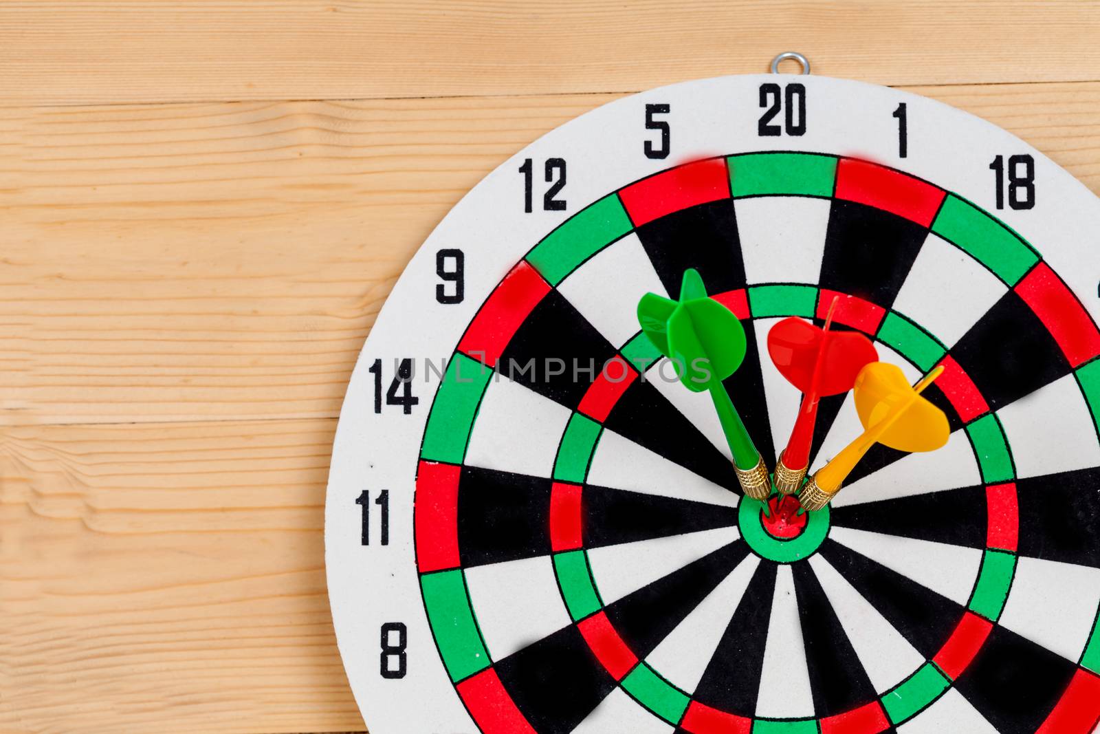 Dart arrow hitting in bullseye on dartboard