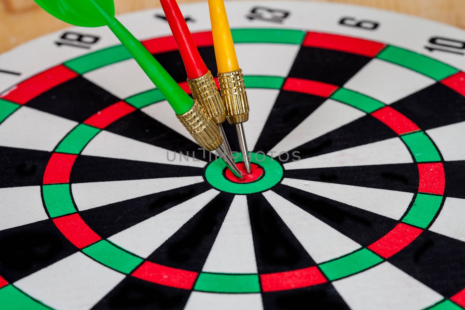 Dart arrow hitting in bullseye on dartboard
