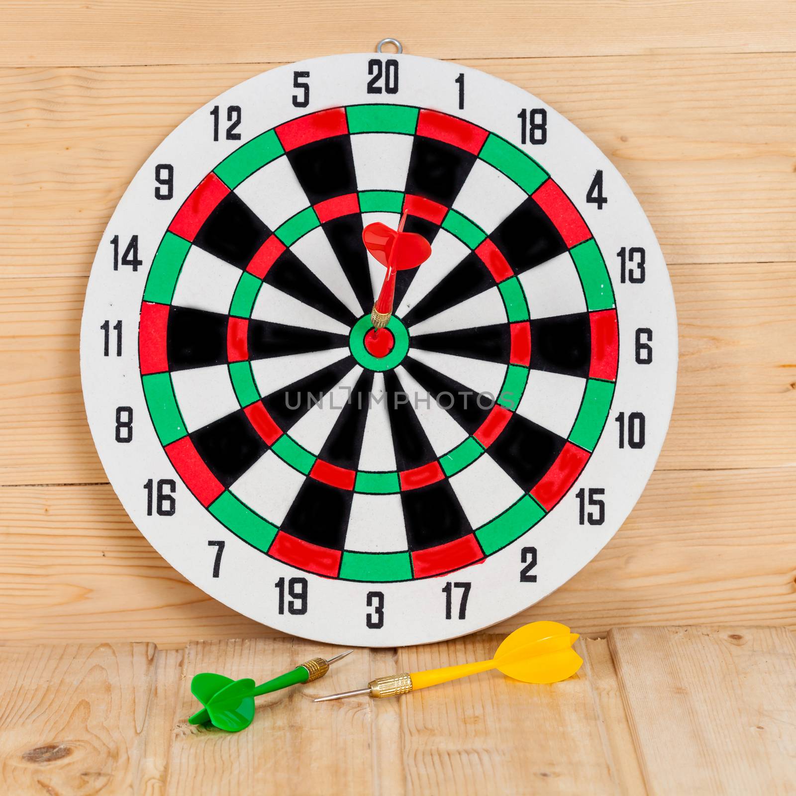 Dart arrow hitting in bullseye on dartboard