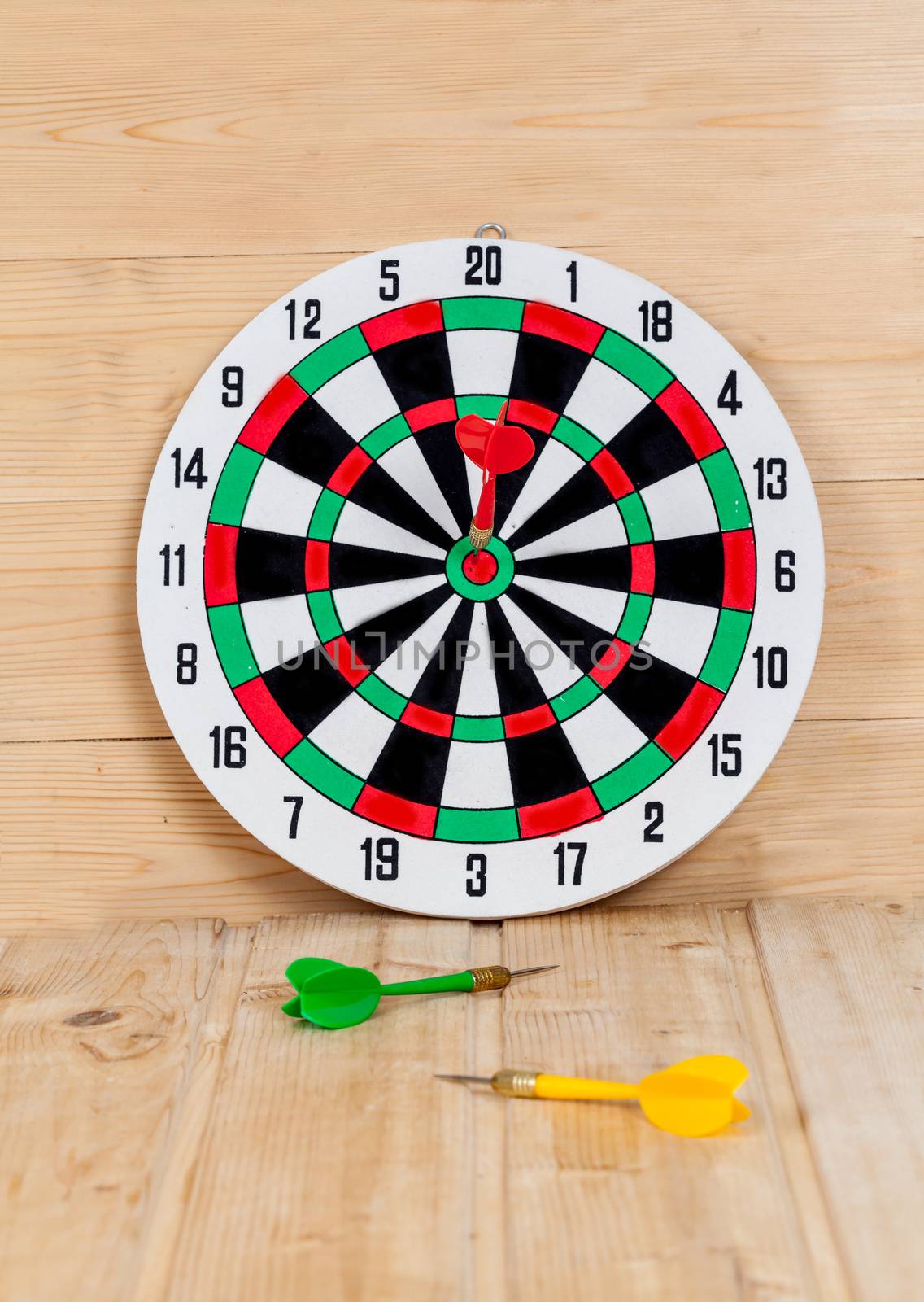 Dart arrow hitting in bullseye on dartboard
