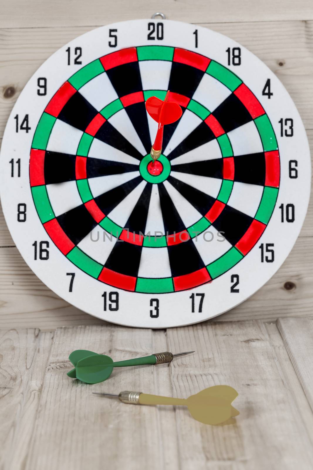 Dart arrow hitting in bullseye on dartboard
