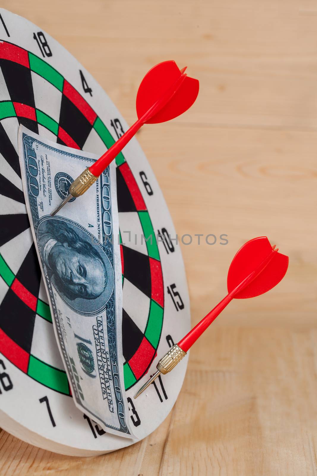 Dart arrow hitting in bullseye on dartboard with money