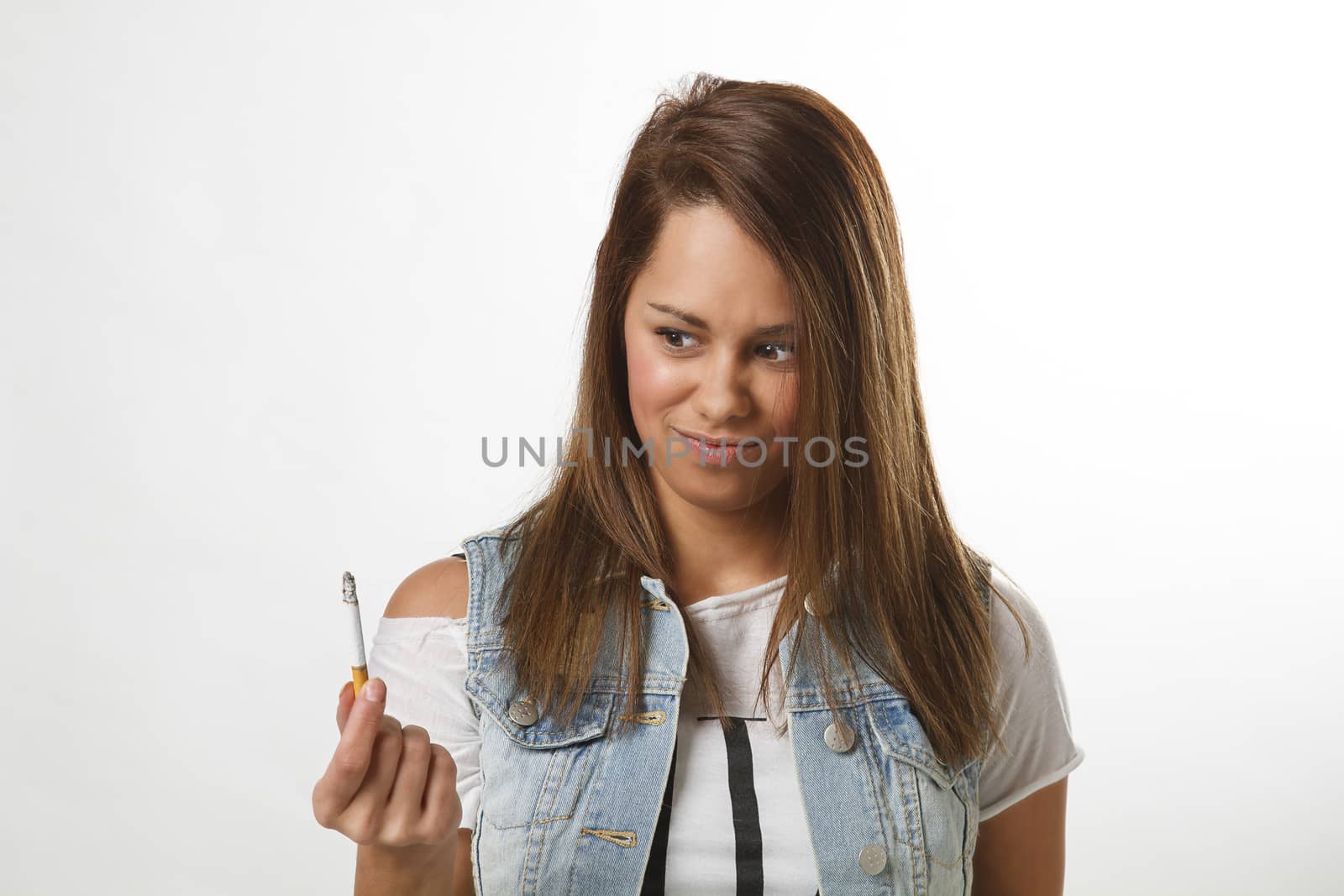 twenty something girl holding a cigarette with digusted look